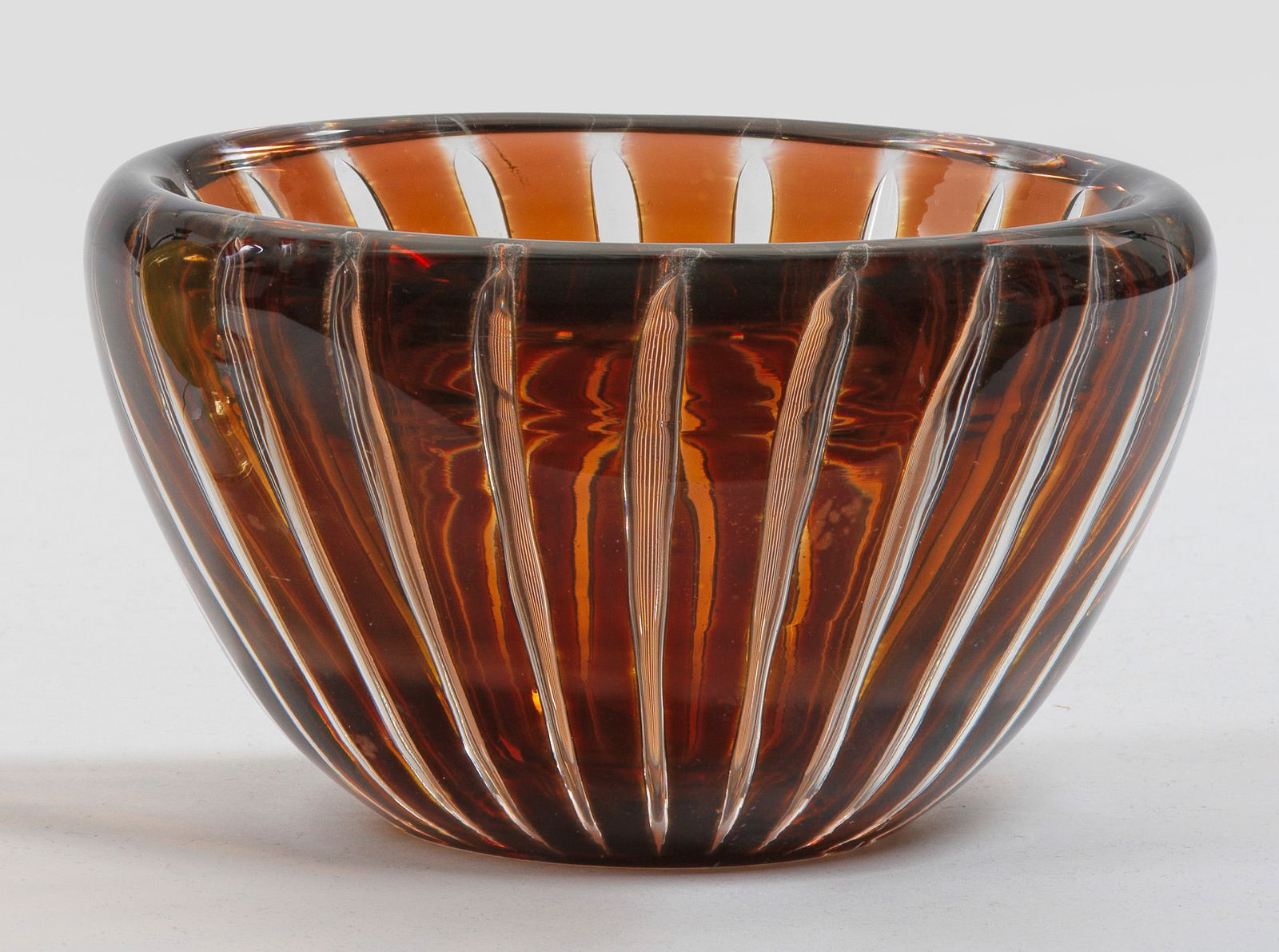 Ziervase von Edvin Öhrström: Farbloses Glas mit eingeschmolzenen Rippen, teilw. brauner Unterfang. Entw. Edvin Öhrström, Werk-Nr. 677 E. Sign.; H. 9,5 cm. Vasen-D. 16,5 cm. Provenienz: Nachlassauflösung einer süddeutschen Pri