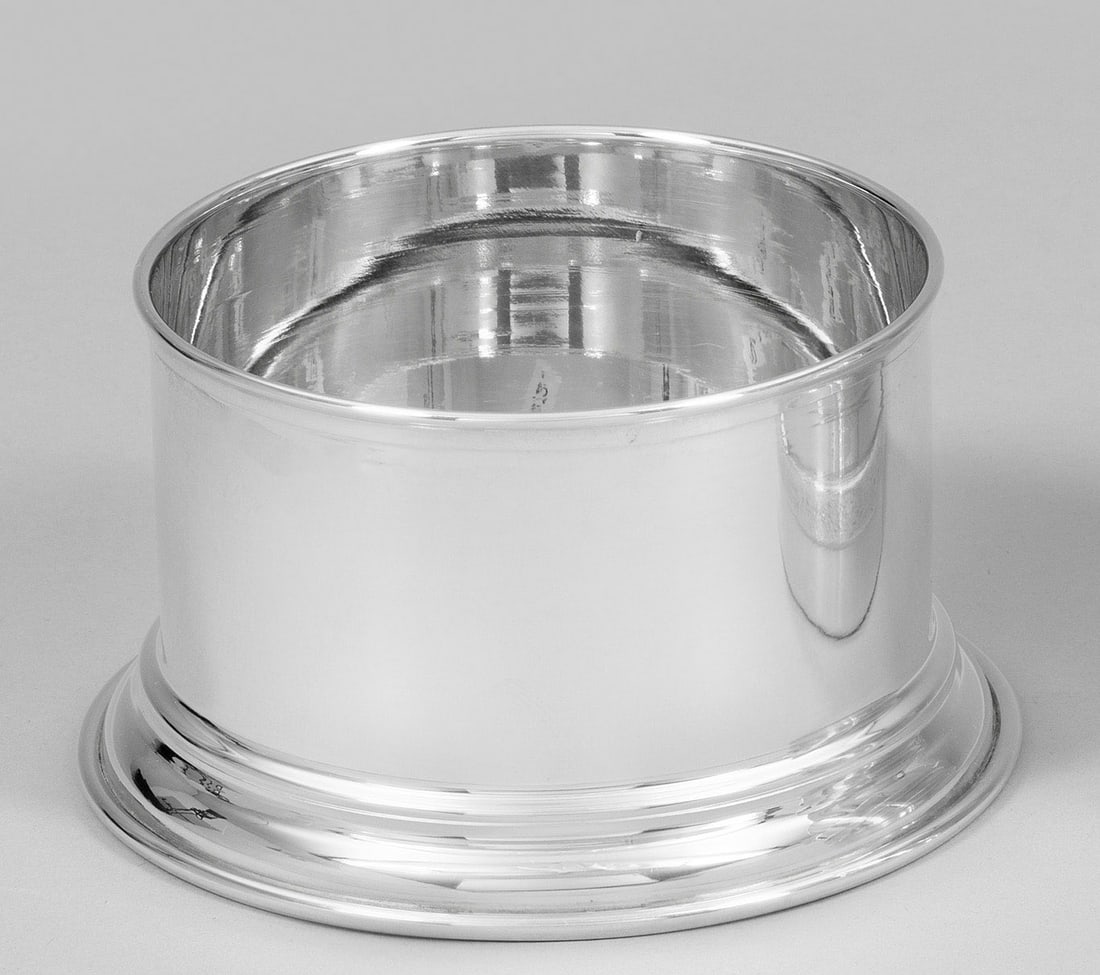 Flaschenuntersetzer: Sterlingsilber. Über getrepptem Stand zylindrische, glatte Wandung. Gest. 925. Gew. ca. 190 g. H. 6,5 cm. D. 12 cm. A German Sterling silver coaster. Standard mark 925. Deutsch. 20. Jh.