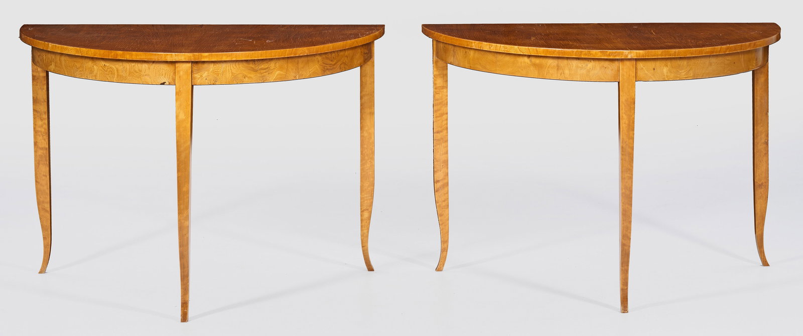 Paar Biedermeier-Demilunetische: Rüster, furniert. Bombierte Zarge auf hohen, konischen und leicht ausgestellten Vierkantbeinen als Träger für gering überstehende Deckplatte jeweils mit halber Sterneinlage, als Salontisch verbind