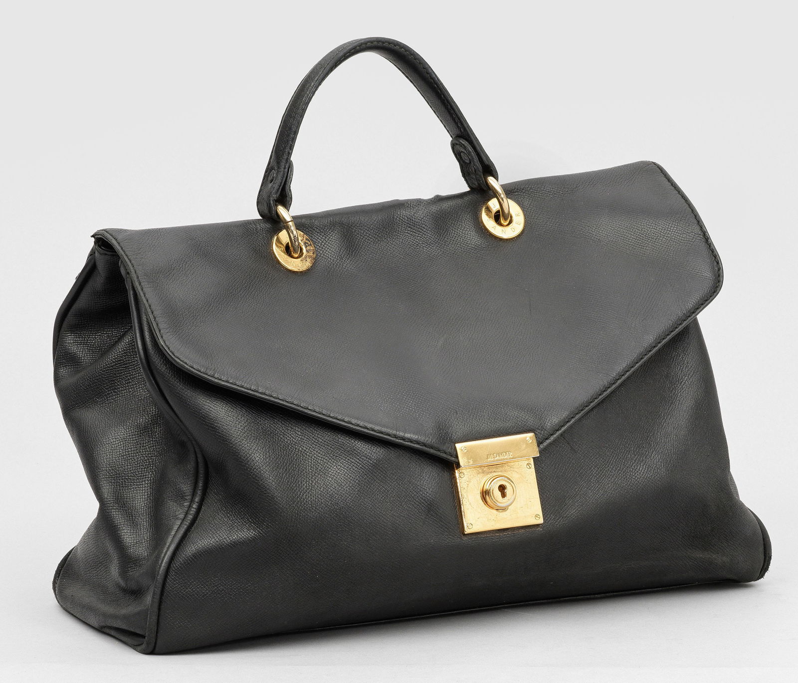 Vintage Handtasche von JIL SANDER: Schwarzes Leder und vergoldete Hardware. Gerundeter Korpus mit Handhabe. Zwei große Hauptfächer. Herstellerzeichen. Gebrauchsspuren. Taschen-H. 23 cm. 40 cm x 15 cm. A Vintage black leather bag by J