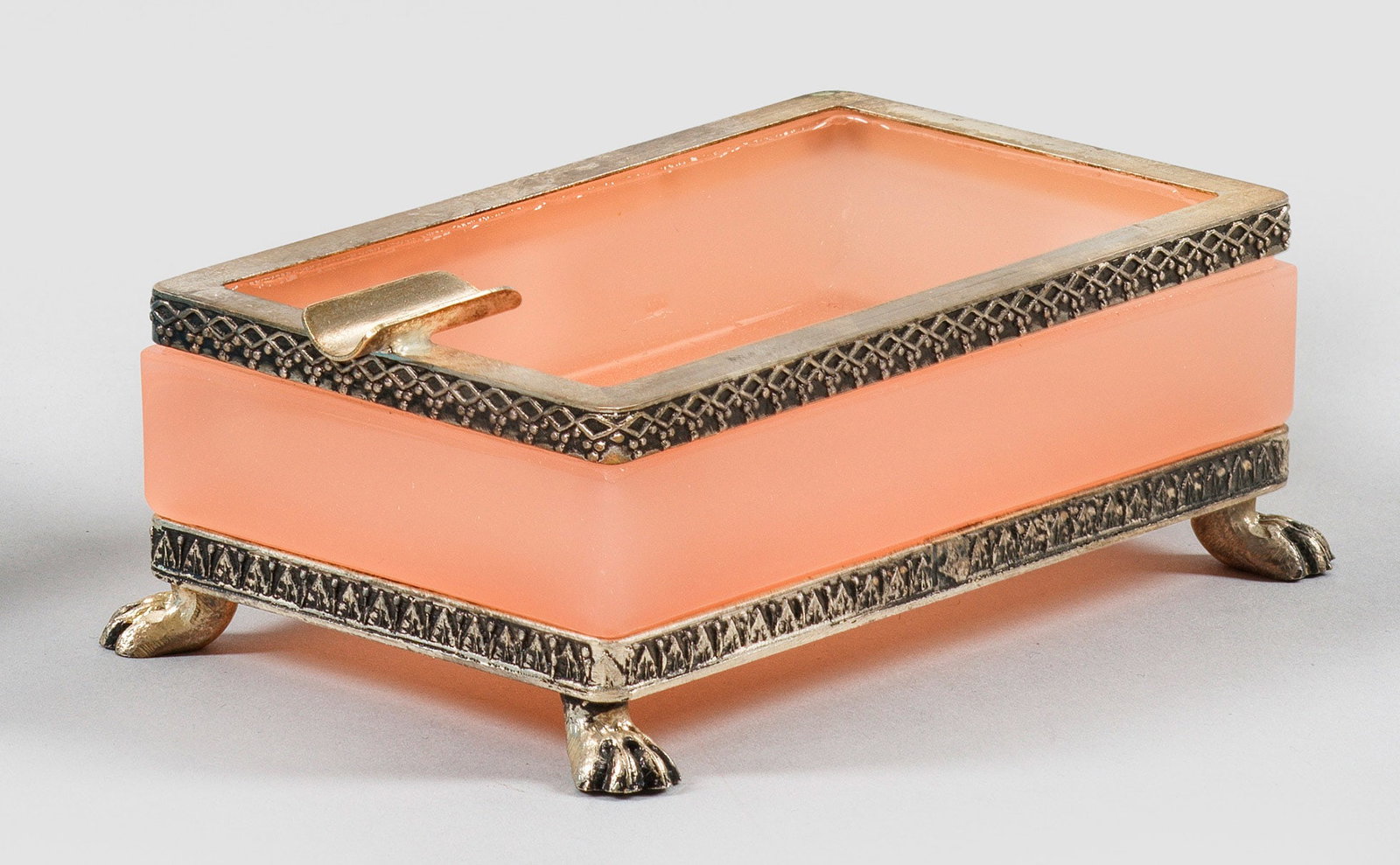 Art Déco-Aschenbecher: Rechteckig. Geschliffenes und poliertes, altrosafarbenes Glas. Montierung mit vier Tatzenfüßen aus versilbertem Metall. H. 4 cm, 11 cm x 6,7 cm. A French Art Deco cut and polished dusky pink glass a