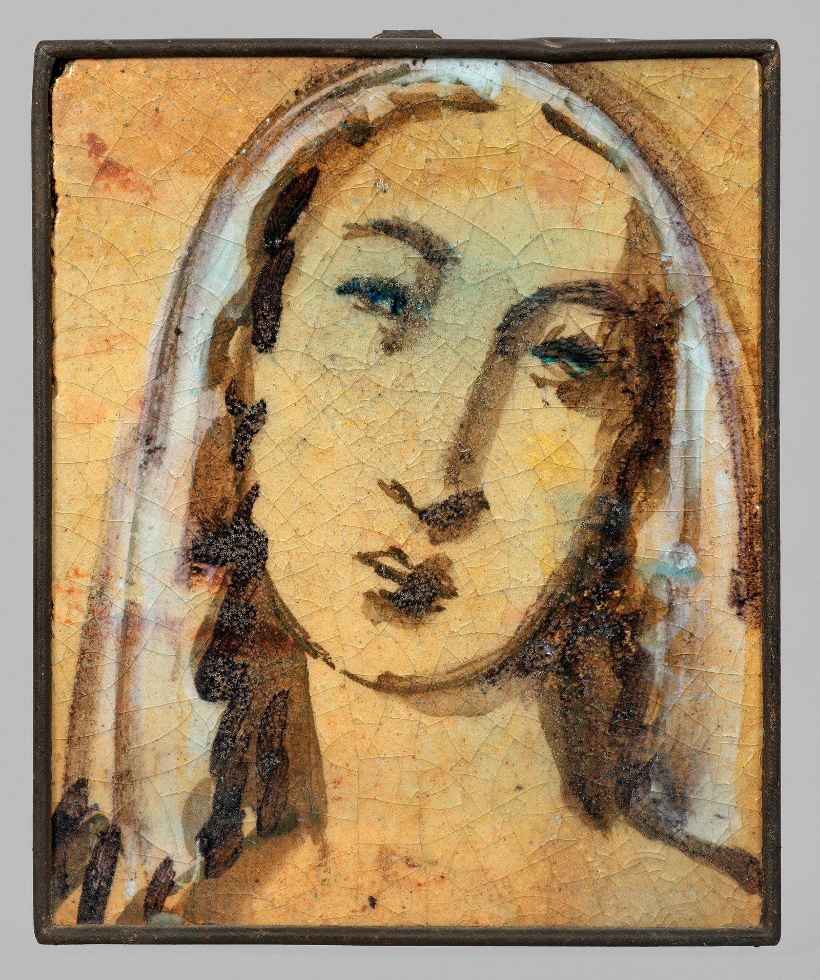 Wandfliese "Weiblicher Kopf": gefasst im Metallrahmen. Irdengut, rotgelber Scherben, gepresst. Polychrome Malerei über dünn aufgetragener Engobe. Transparente, krakeelierte Alkaliglasur. Porträt einer Dame mit schulterlangem Ha