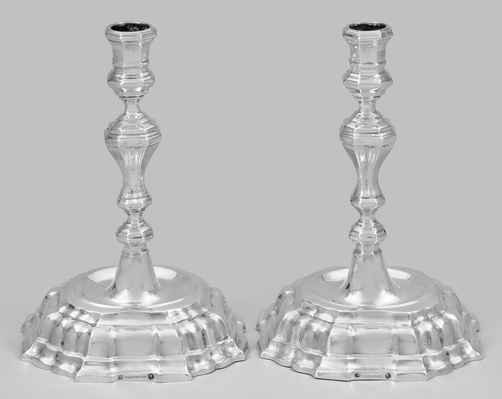 Paar Augsburger Barock-Tafelleuchter: Silber. Gewölbter, passig geschweifter Stand. Über gemuldetem Ansatz hoher, mehrfach gegliederter Balusterschaft sowie facettierte Tülle. Tremolierstrich. Gest. Beschauzeichen, Meister Christian I