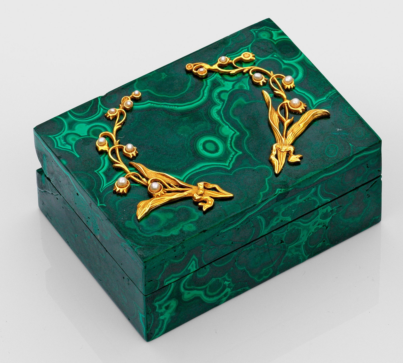 Malachit-Dose: Silber, vergoldet. Rechteckiger Korpus mit gerader Wandung. Auf flachem Scharnierdeckel zwei durchbrochen gearbeitete, vergoldete Silberapplikationen in Form von Maiglöckchenzweigen. Blüten besetzt