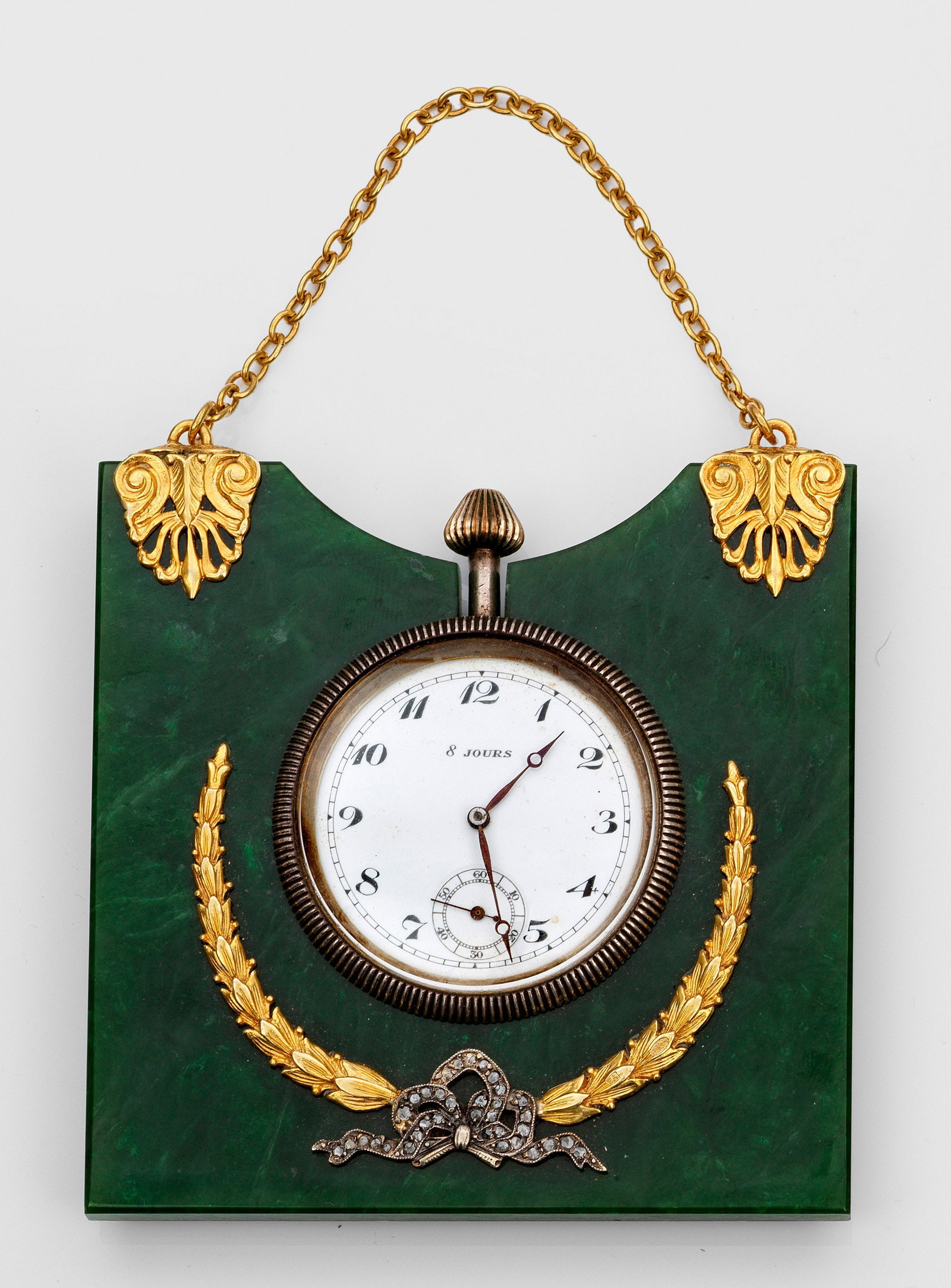 Nephrit-Wanduhr: im Stil von Karl Fabergé. Silber, teilw. vergoldet, Nephrit. Oben konkav geschwungene dunkelgrüne Nephrit-Platte, darin eingelassene Uhr mit silberner Lünette und weißes Zifferblatt mit schwarzen,