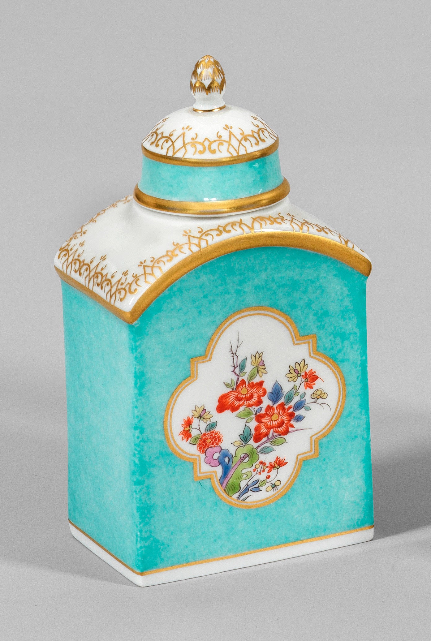 Teedose mit Kakiemondekor und seegrünem Fond: Hochrechteckiger Korpus mit gerundeter Schulter und kurzem, zylindrischem Hals. Passiger Stülpdeckel mit Pinienknauf. Seegrüner Grund. Beidseitig zentral der Wandung goldkonturierte Vierpasskartusch