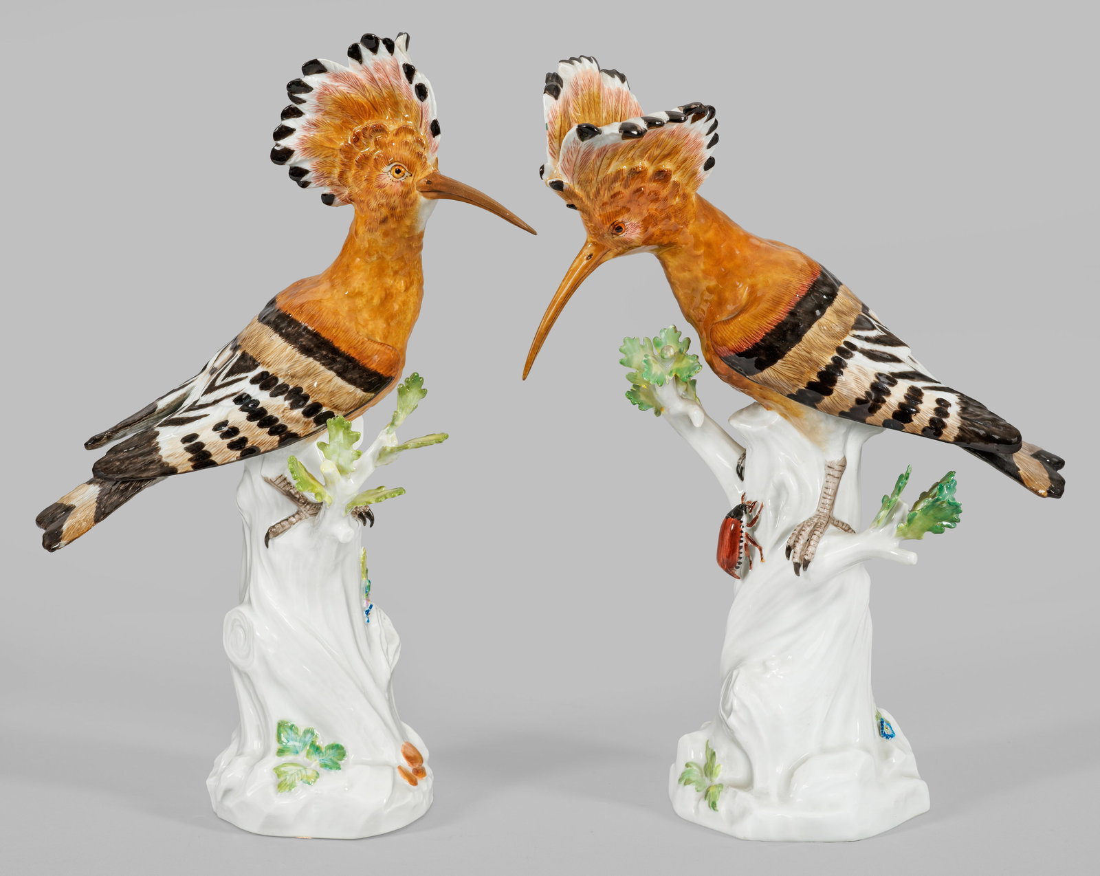 Paar Wiedehopfe: Gegenstücke. Auf Baumstumpfsockel mit Eichenblättern, teilw. plastischen Blatt- und Blütenbelag, sitzender Wiedehopf mit fein reliefiertem Gefieder und einer akzentuierten, aufgerichteten Federhaub