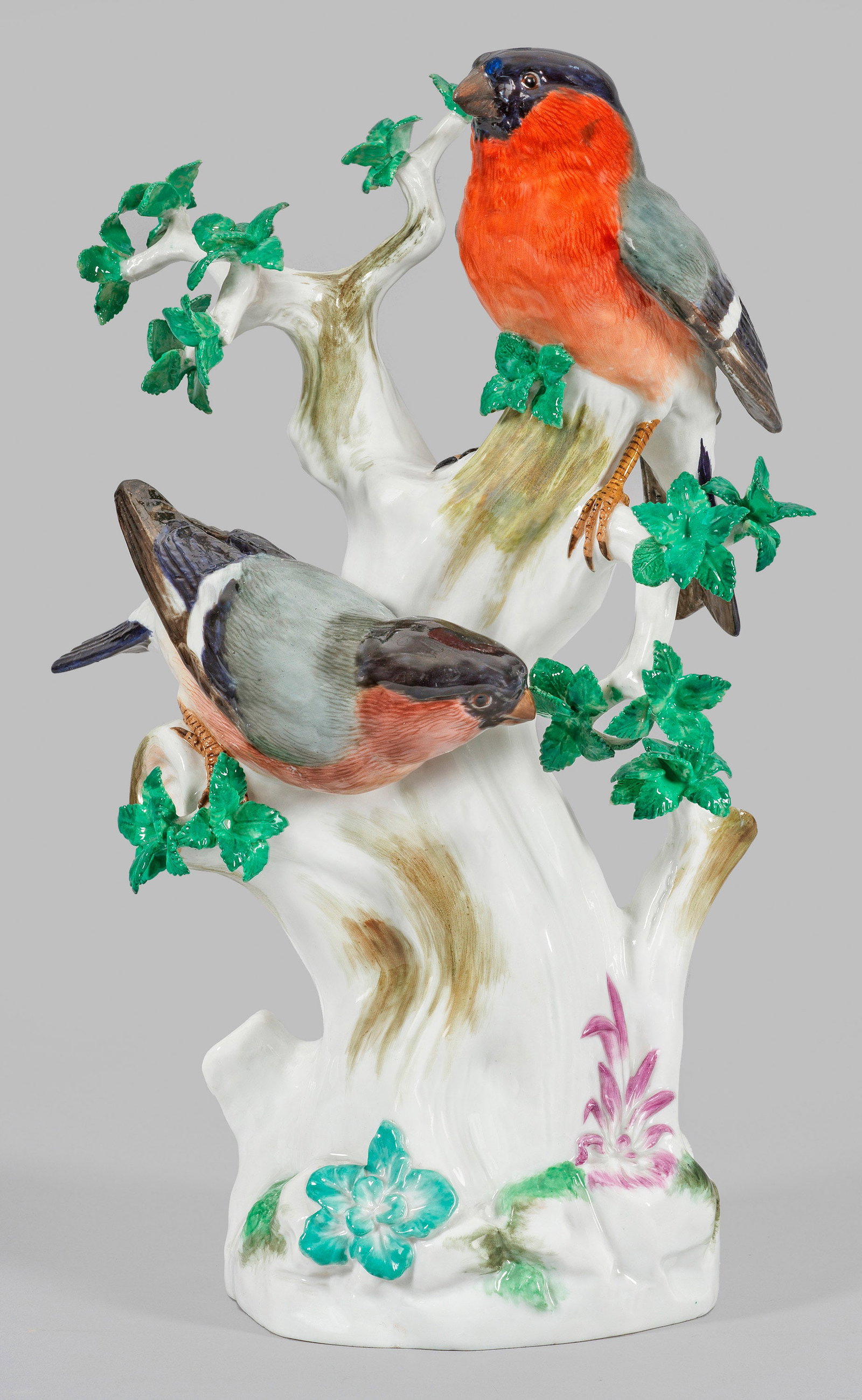 Gimpelgruppe: Auf den Ästen eines mit Blättern und Farnen belegten Baumes, zwei sitzende Gimpel mit farbenprächtigem, naturalistischem Gefieder. Äste mit plastischen Blättern. Polychrome Malerei. Entw. August