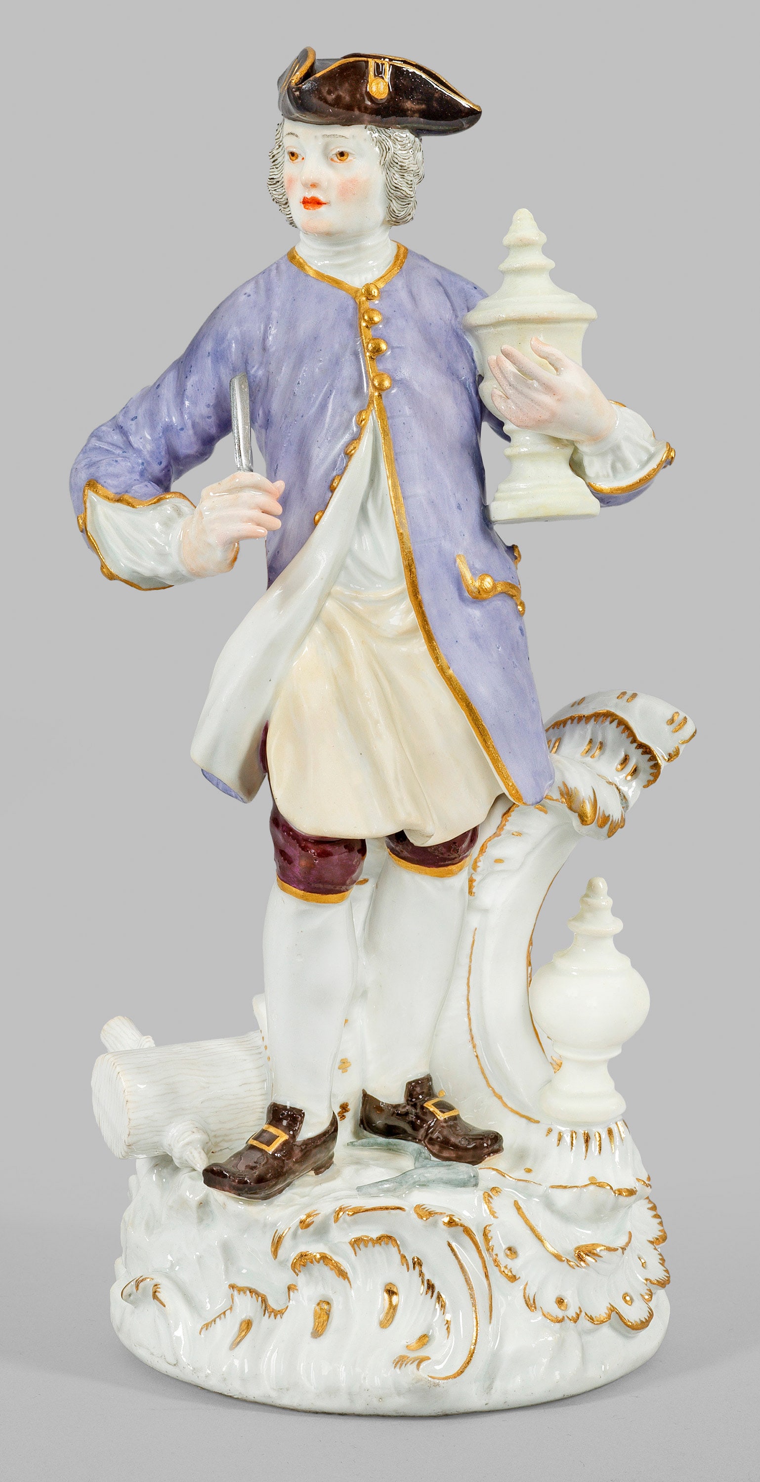 Handwerker-Figur als Drechsler: Auf einem Rocaillesockel mit Attributen seines Handwerksstandes stehender, in feinen Mantel und Schürze gewandeter Drechsler, Meißel und ein Deckelpokal in den Händen haltend. Auf dem Boden liegend