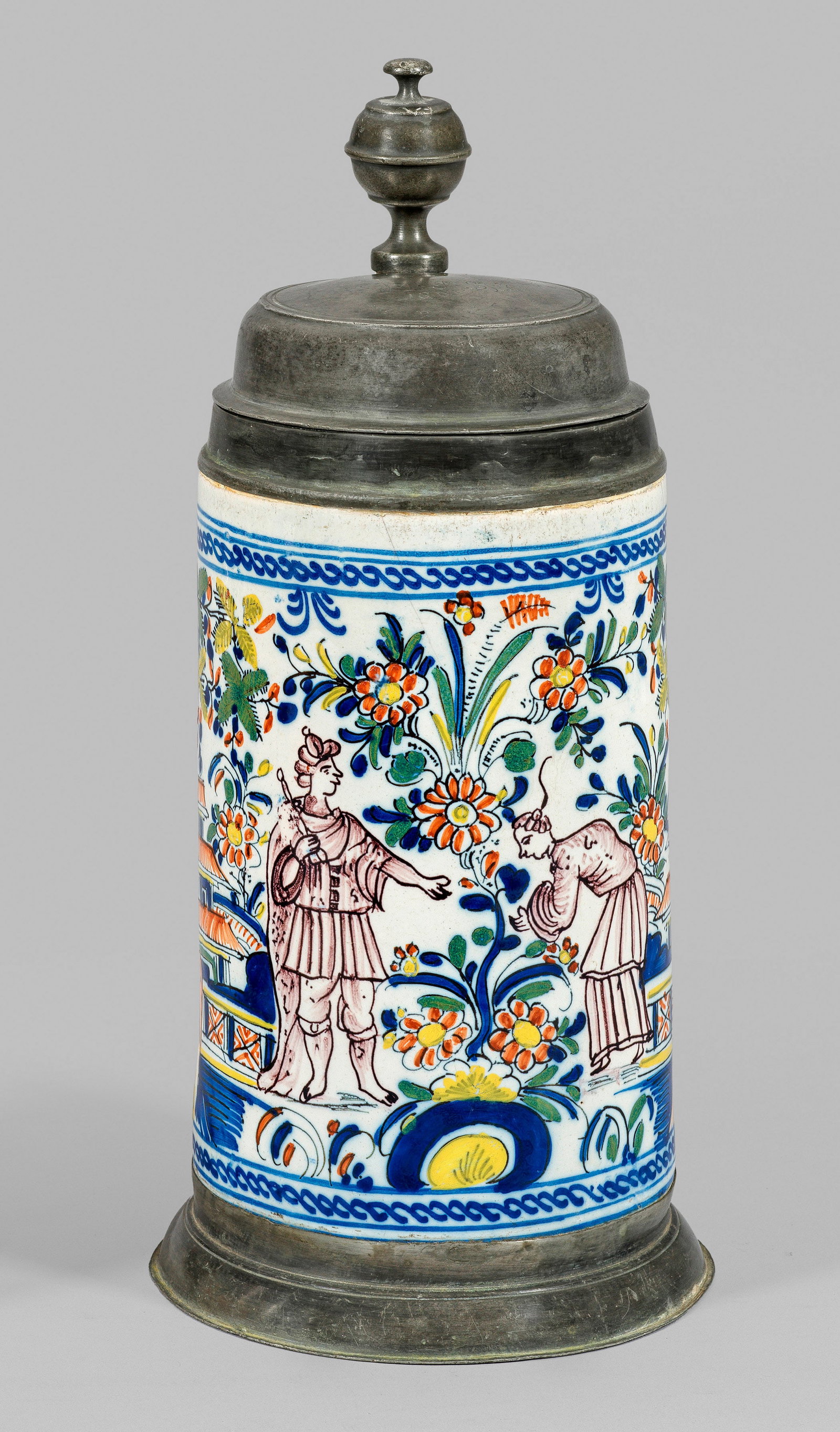 Walzenkrug mit Chinoiserien: Fayence. Polychromer Scharffeuerdekor mit Chinesen in blühender Gartenlandschaft eingefasst von Kordelbordüre. Zinnmontierter Bandhenkel sowie Fuß- mit Kügeldrücker. Auf dem Deckel die Initialen