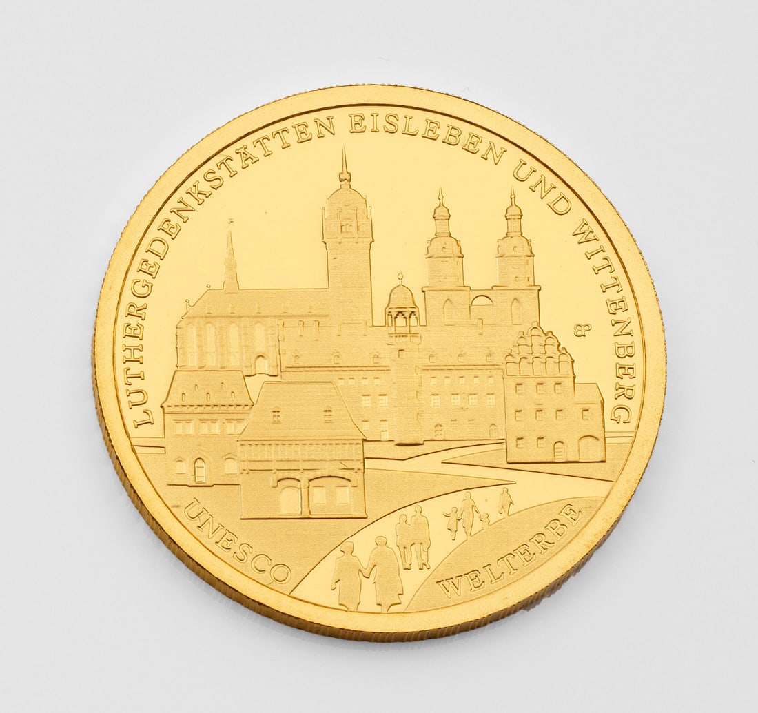 100 Euro Goldmünze "UNESCO Weltkulturerbe Eisleben 2017": Feingehalt 999,9. Beidseitig geprägt: UNESCO Welterbe Luther Gedenkstätten Eisleben und Wittenberg sowie Bundesrepublik Deutschland 2017 mit Adler. Klare Kunststoff-Box und Original-Box. D. 28 mm. G