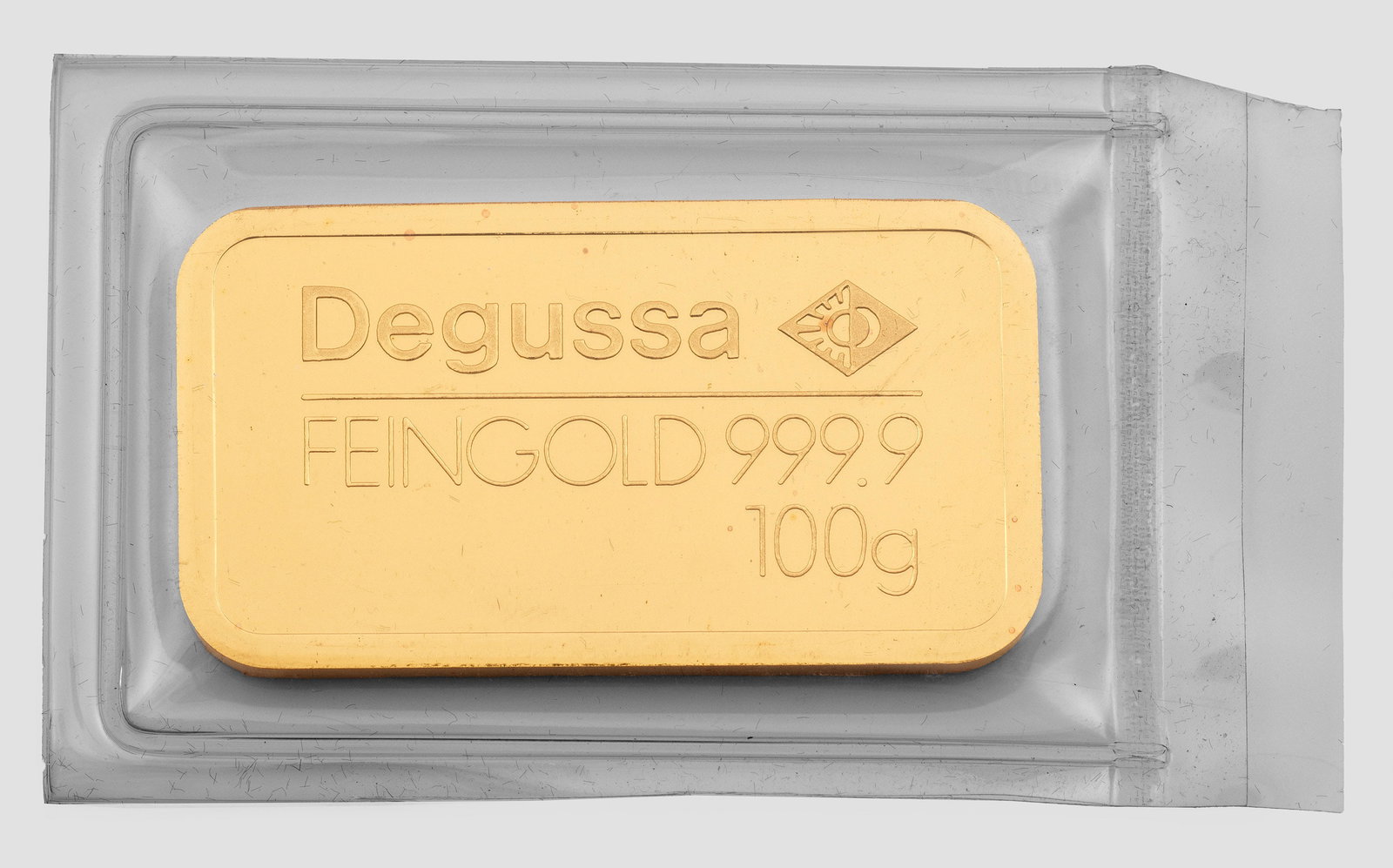 Degussa Feingoldbarren-"Sargbarren": Feingehalt 999,9. Herstellerzeichen. Gew. 100 g. Kunststoff-Blister, Einschweißverpackung. Gold bar by Degussa, in 999,9 gold. Manufacturer's mark.