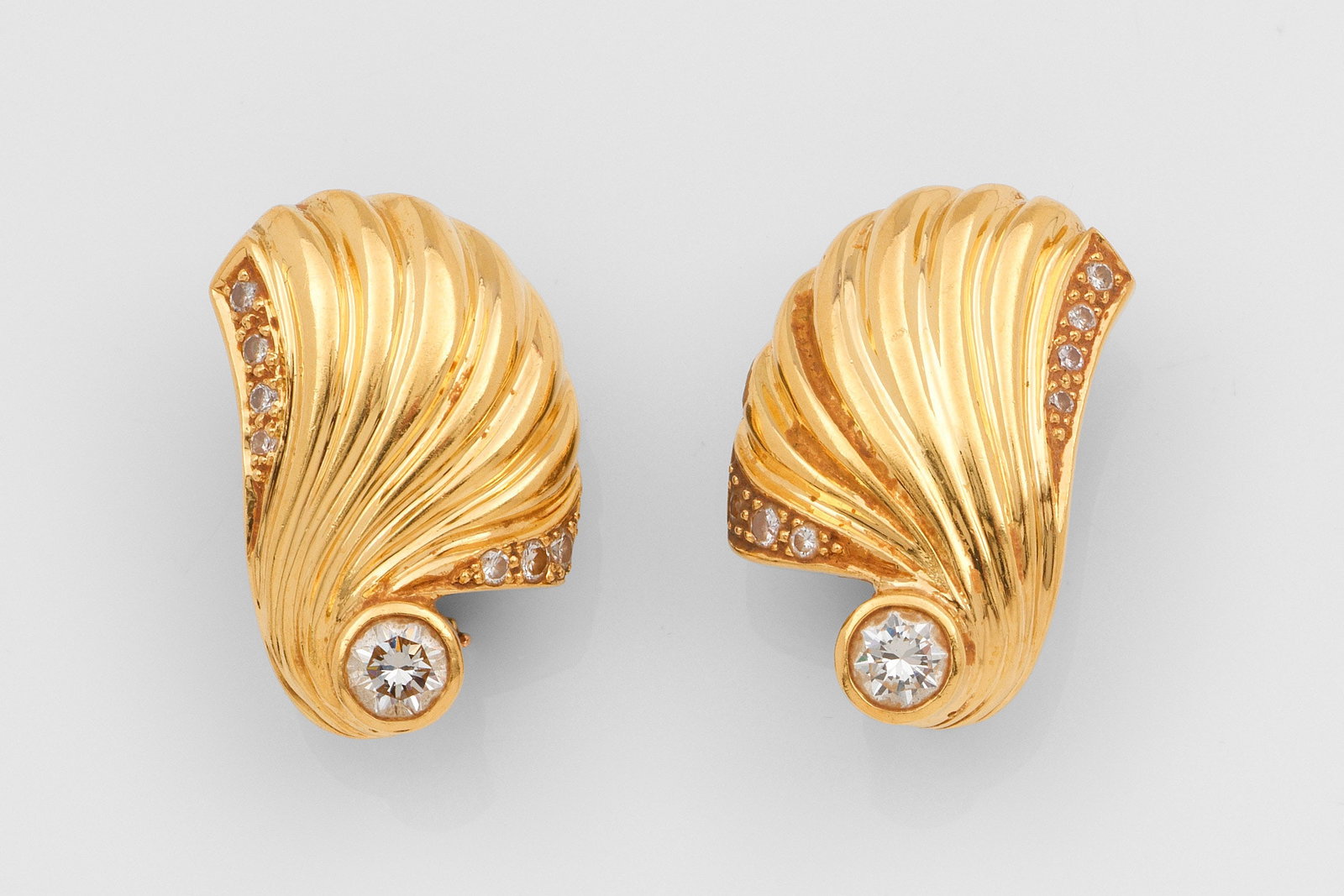 Paar dekorative Brillant-Ohrclips: Gelbgold, gest. 750. Schauseitig besetzt mit 2 Brillanten von zus. ca. 0,50 ct.; Ges.-Gew. ca. 15,08 g. Pair of earclips set with 2 diamonds approx. 0,50 ct., in 18 k gold.