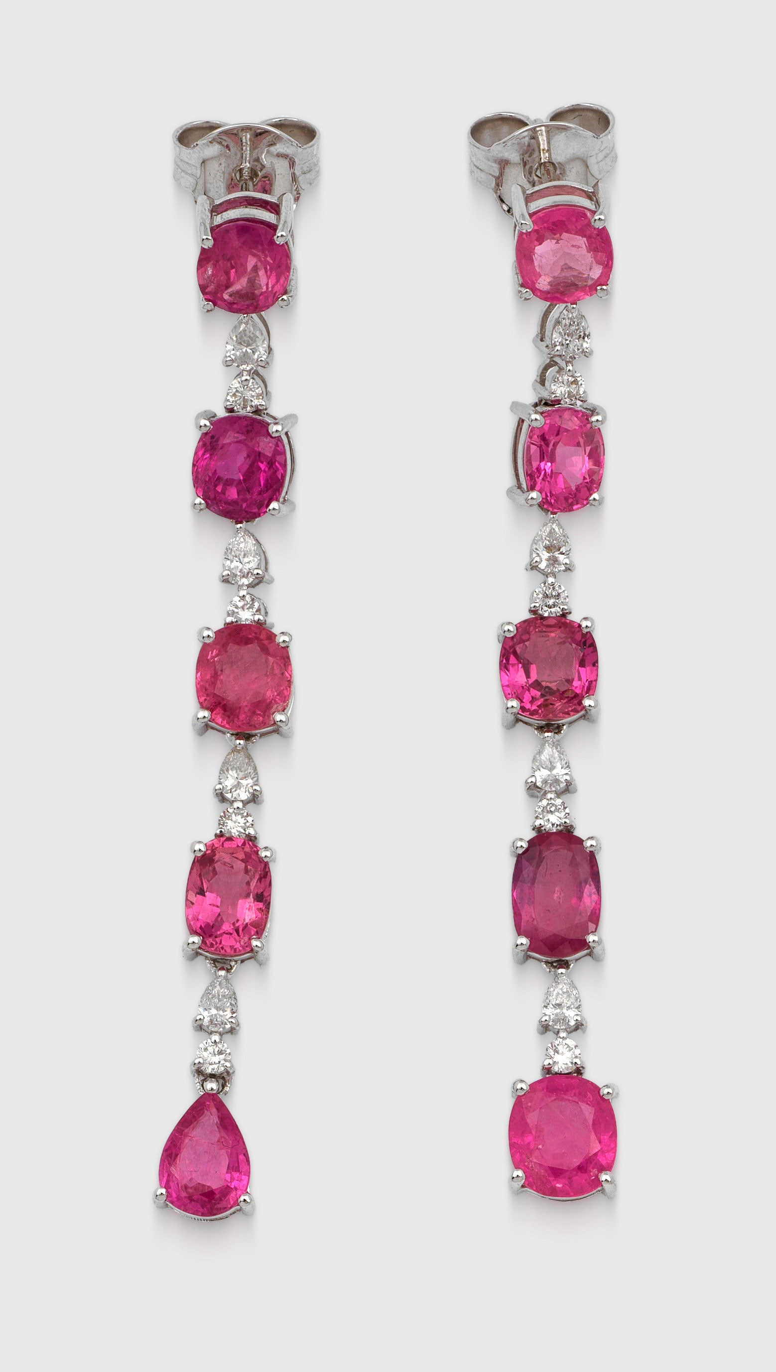 Paar elegante Saphir-Ohrgehänge: Weißgold, gest. 750. Linear ausgefasst mit pinken, purple und orangy-pinken Saphiren von zus. ca. 11,44 ct. im Oval- und Cushioncut, getrennt von Brillanten und Diamanten im Pearcut von zus. ca. 0,55