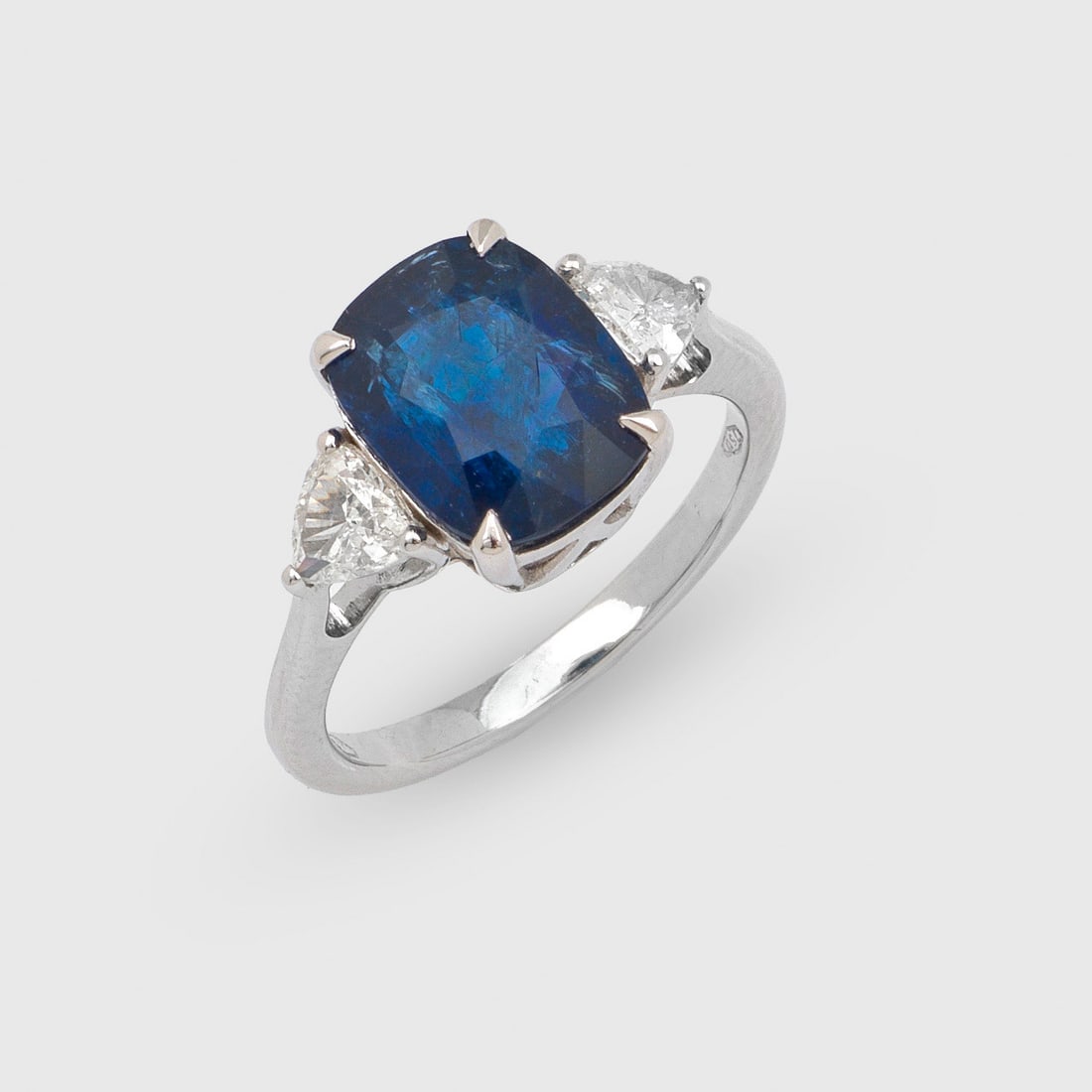 Klassischer Burma-Saphirring: Weißgold, gest. 750. Zentral besetzt mit einem intense blue Burma-Saphir von ca. 4,68 ct. im Cushioncut, flankiert von zwei Diamanten von zus. ca. 0,50 ct. (I-J/vss-vs) im Trillioncut. Gew. ca. 4,75