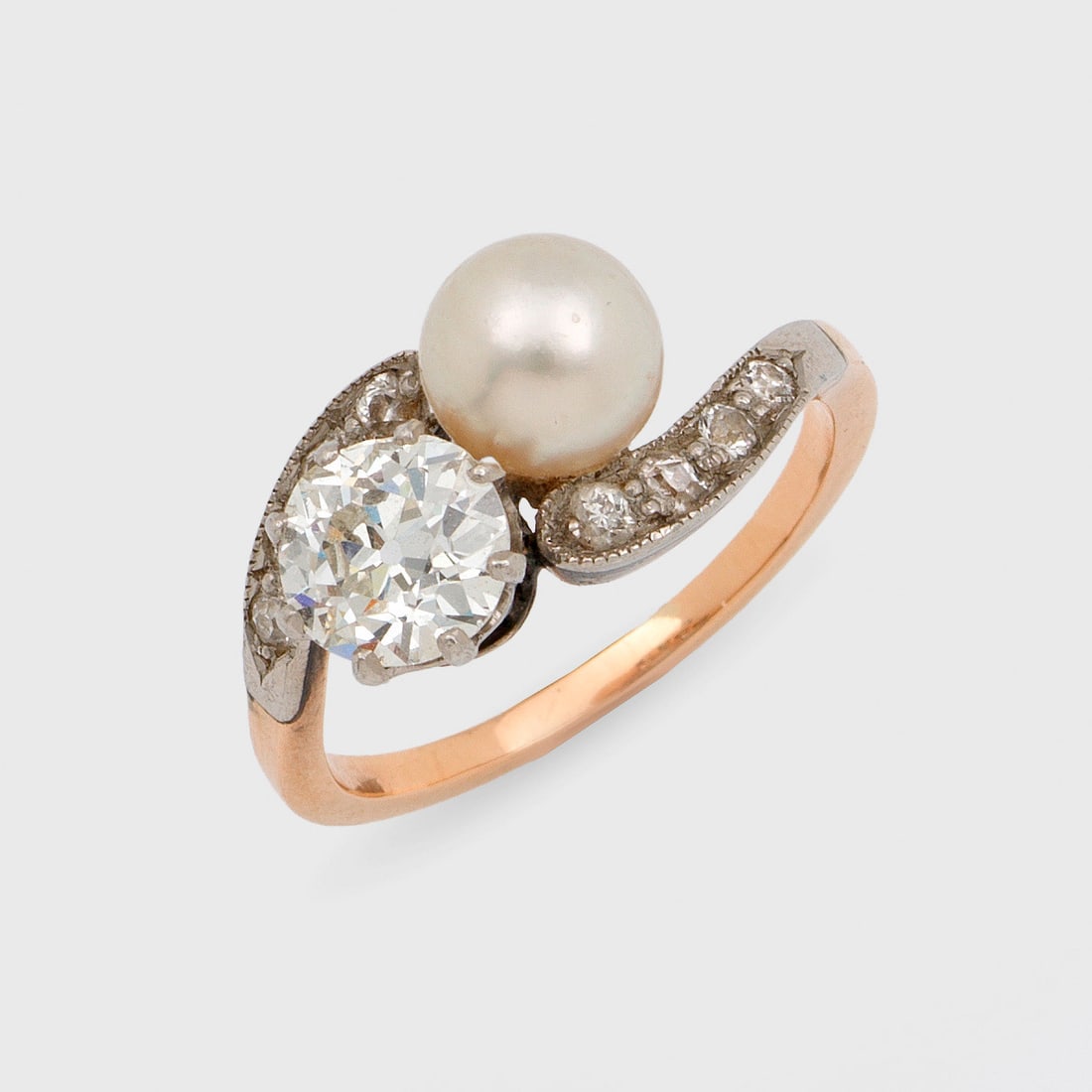 Feiner Jugendstil "Toi & Moi"-Diamant-Perlring: Roségold, 8 ct.; Diagonal verlaufende Ringschiene, besetzt mit ecrufarbener Perle von ca. 6 mm in sehr farbintensivem rosé-grün changierendem Lüster und Altschliffdiamanten von ca. 0,75 ct.; Gew.