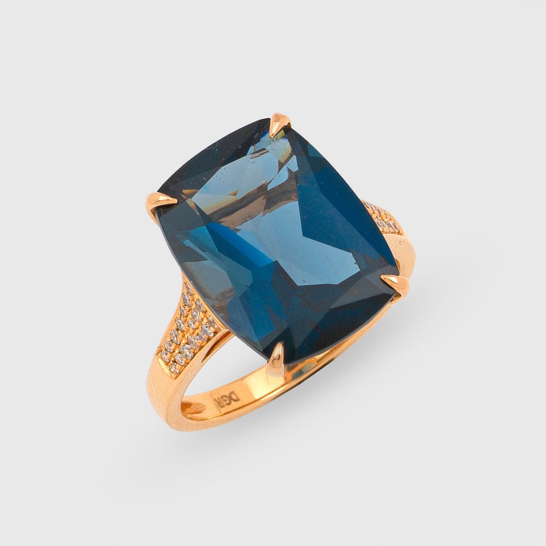 Repräsentativer London Blue Topas-Ring: Roségold, gest. 750. Zentral besetzt mit einem London Blue-Topas von ca. 10,80 ct. im Cushioncut, flankiert von Brillanten von zus. ca. 0,20 ct.; Gew. ca. 5,62 g. Ring set with a London blue topaz ap
