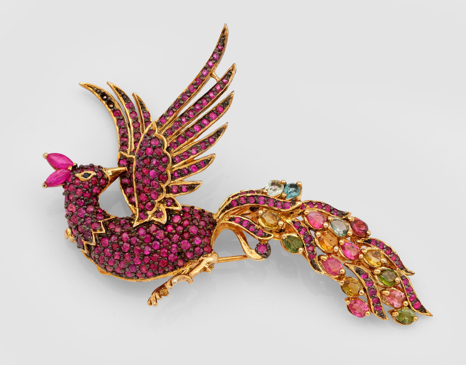 Repräsentative Rubin-Turmalin-Brosche: Silber, vergoldet, gest. 925. Dekorativ gestaltet in Form eines Pfauen, ausgefasst mit Rubinen von zus. ca. 8,89 ct. und Turmalinen von zus. ca. 3,50 ct.; Gew. ca. 18,65 g. Brooch set with rubies appr