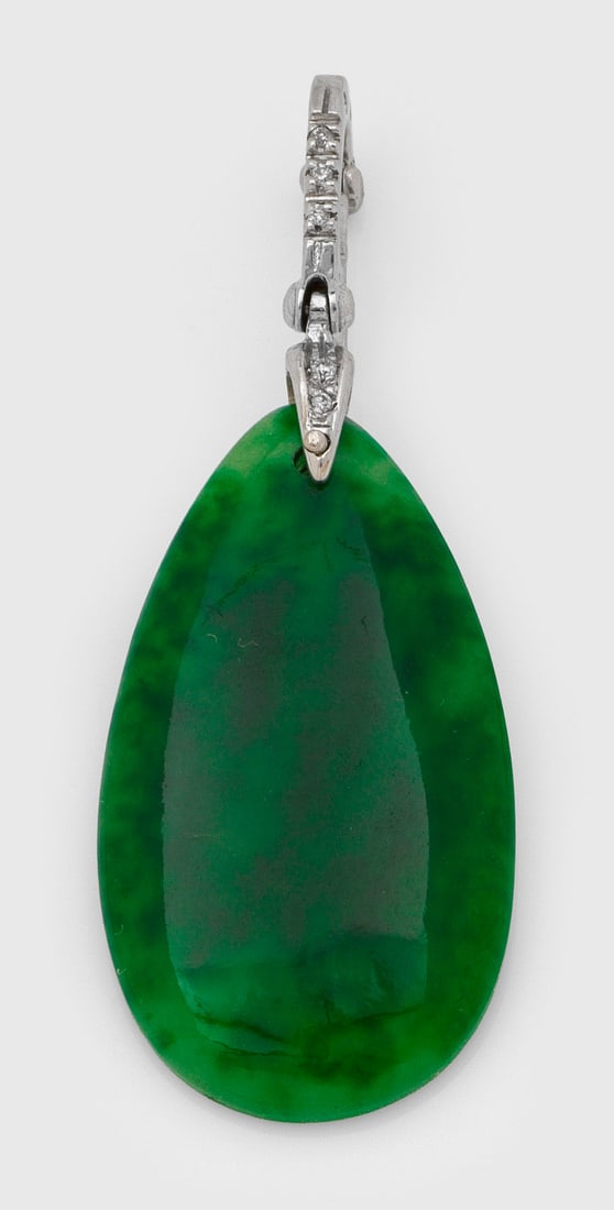 Dekorativer Jade-Anhänger: Weißgold, gest. 750. Zentral besetzt mit tropfenförmiger, moosgrüner Jade von ca. 30 x 17 mm, akzentuiert von kleinen Brillanten. Gew. ca. 4,88 g. Pendant set with green jade and small diamonds, in