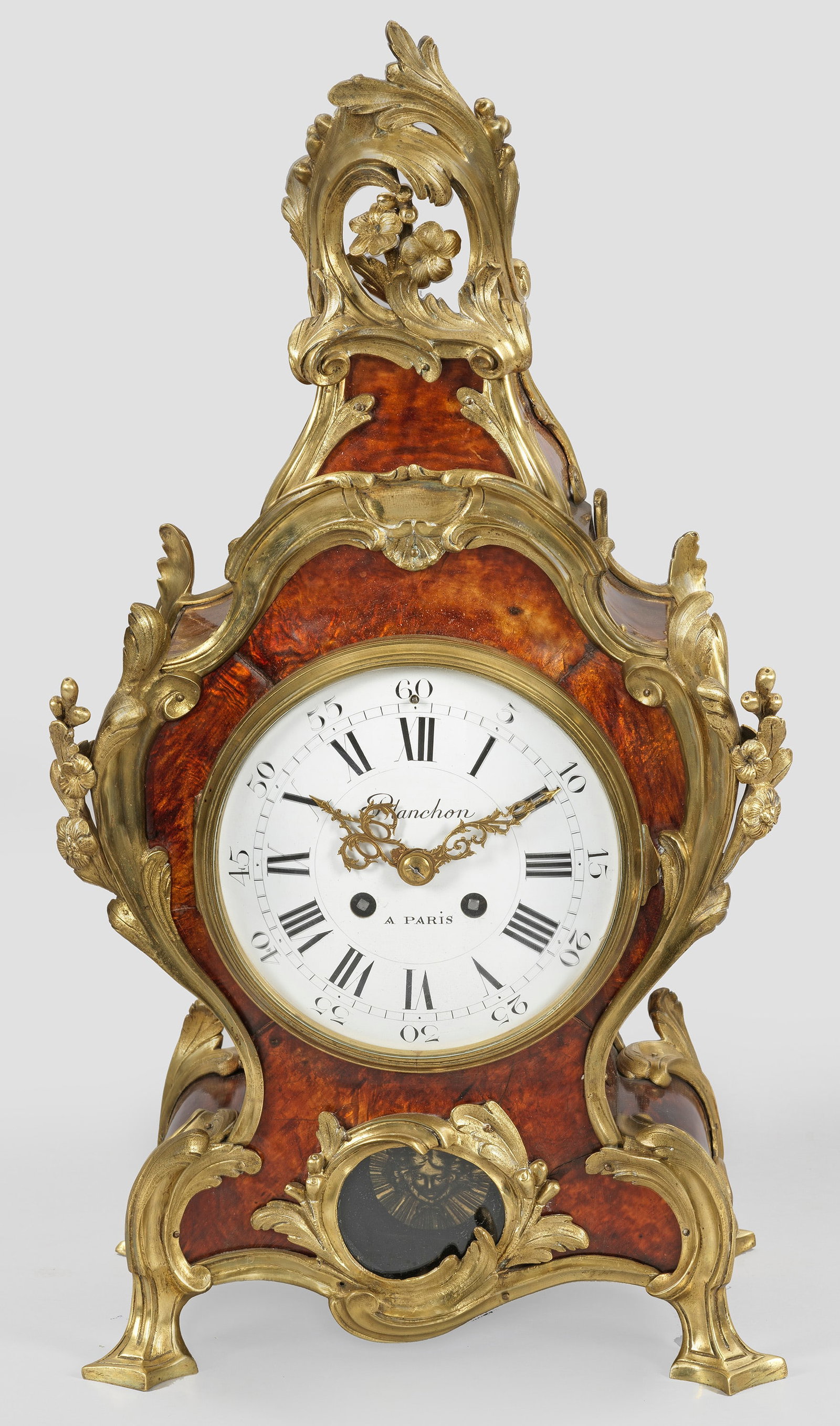 Louis XV-Pendule: Flächendeckender Fond aus schildpattfarbenem Chinalack sowie vergoldete Bronze. Balusterförmiger Korpus, flankiert von üppigen Volutenmotiven. Geschweift ansteigender, oberer Abschluss aus asymmetr