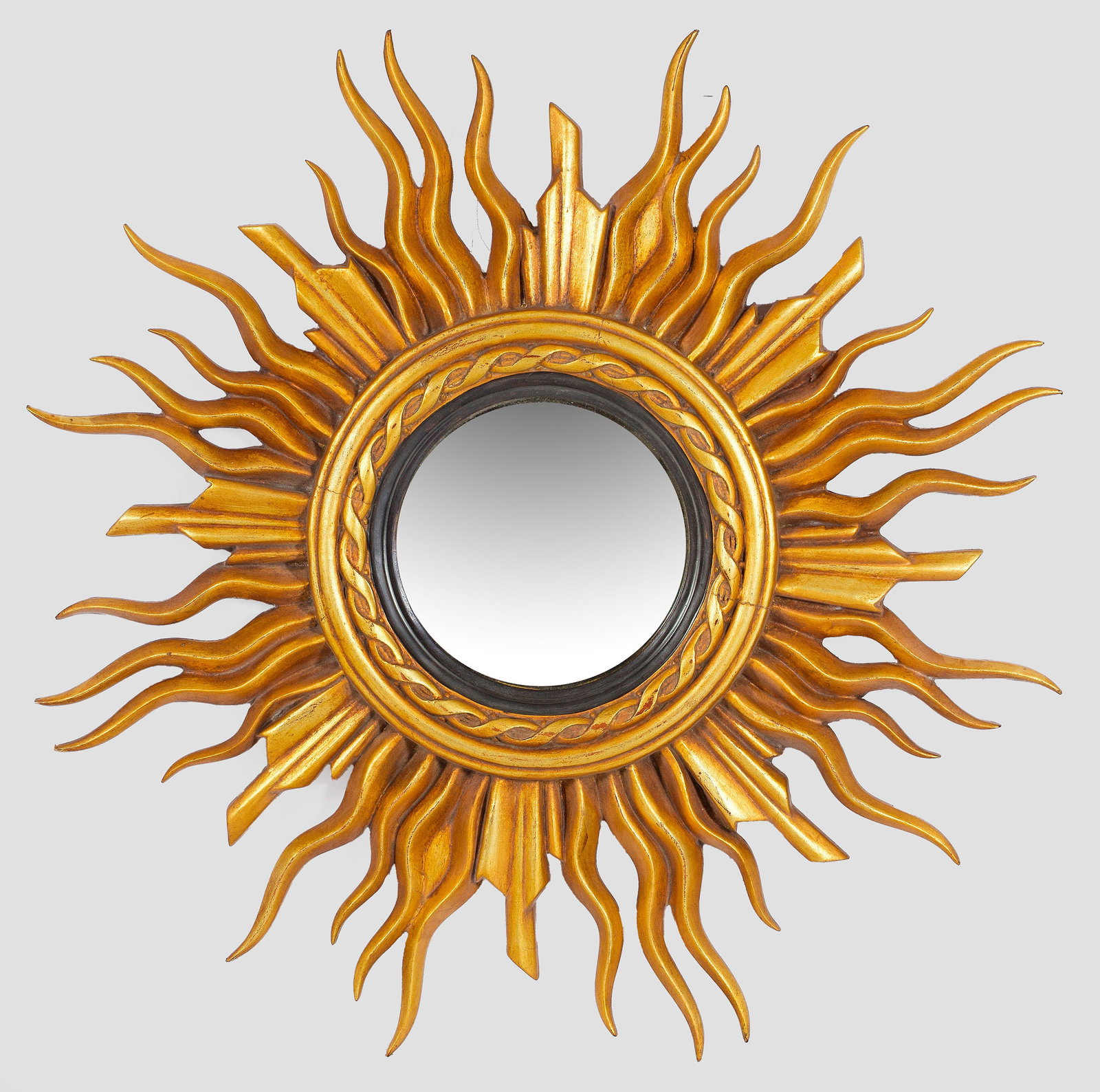 Großer Sonnenspiegel: Holz, goldfarben und teilw. schwarz lackiert. Profilierte Spiegelrahmung mit Wellenbandfries, umgeben von dicht angeordneten, geschwungenen Strahlen. Spiegelglas. D. 90 cm. A French gold lacquered mir