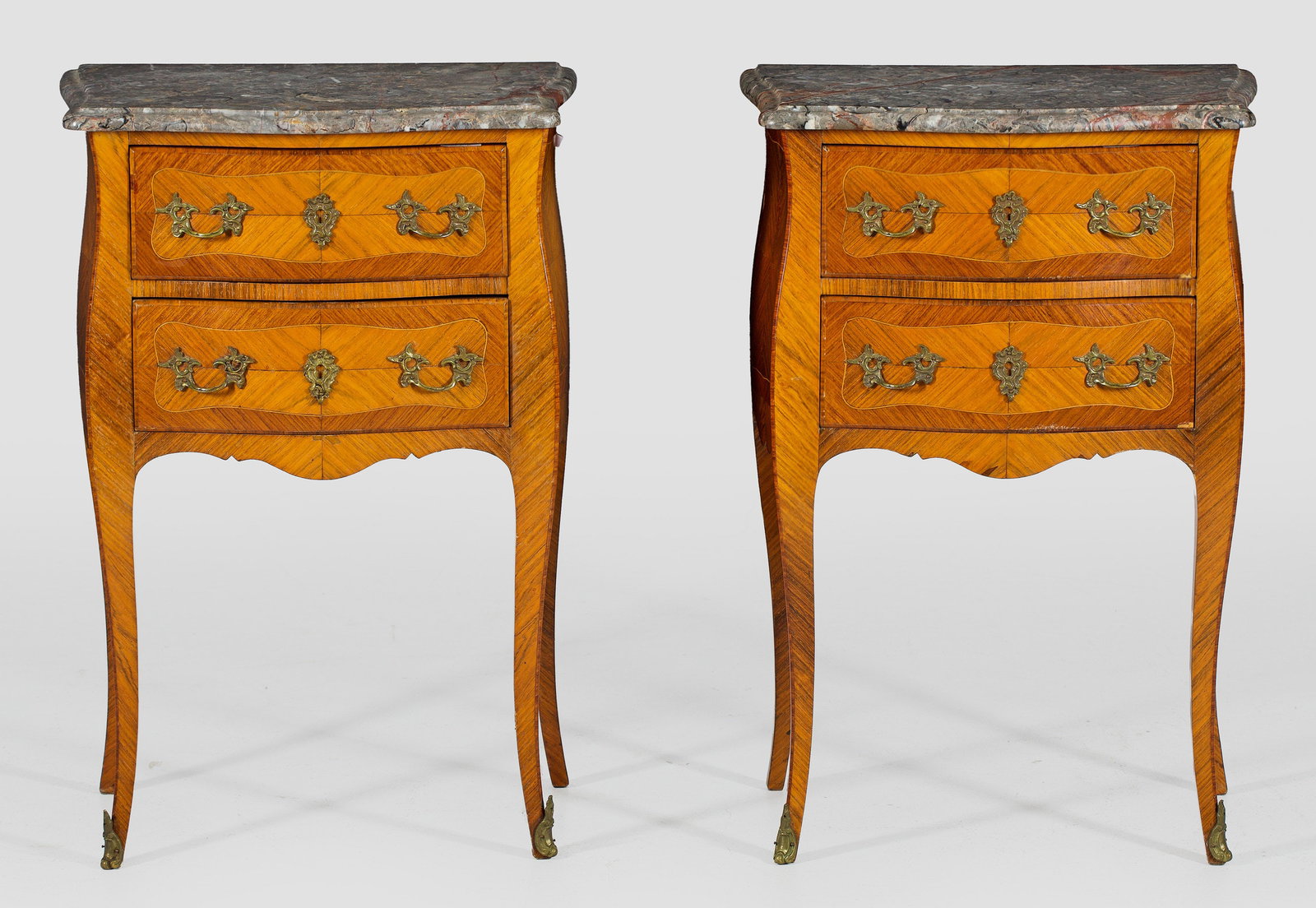 Paar Pfeilerkommoden Im Louis XV-Stil: Palisander und Rosenholz, furniert. Dreiseitig bombierter Korpus, flankiert von schmalen Ecklisenen auf hohen, geschwungenen Beinen. In der gegliederten Front zwei Schubfächer. Flächendeckend gespie