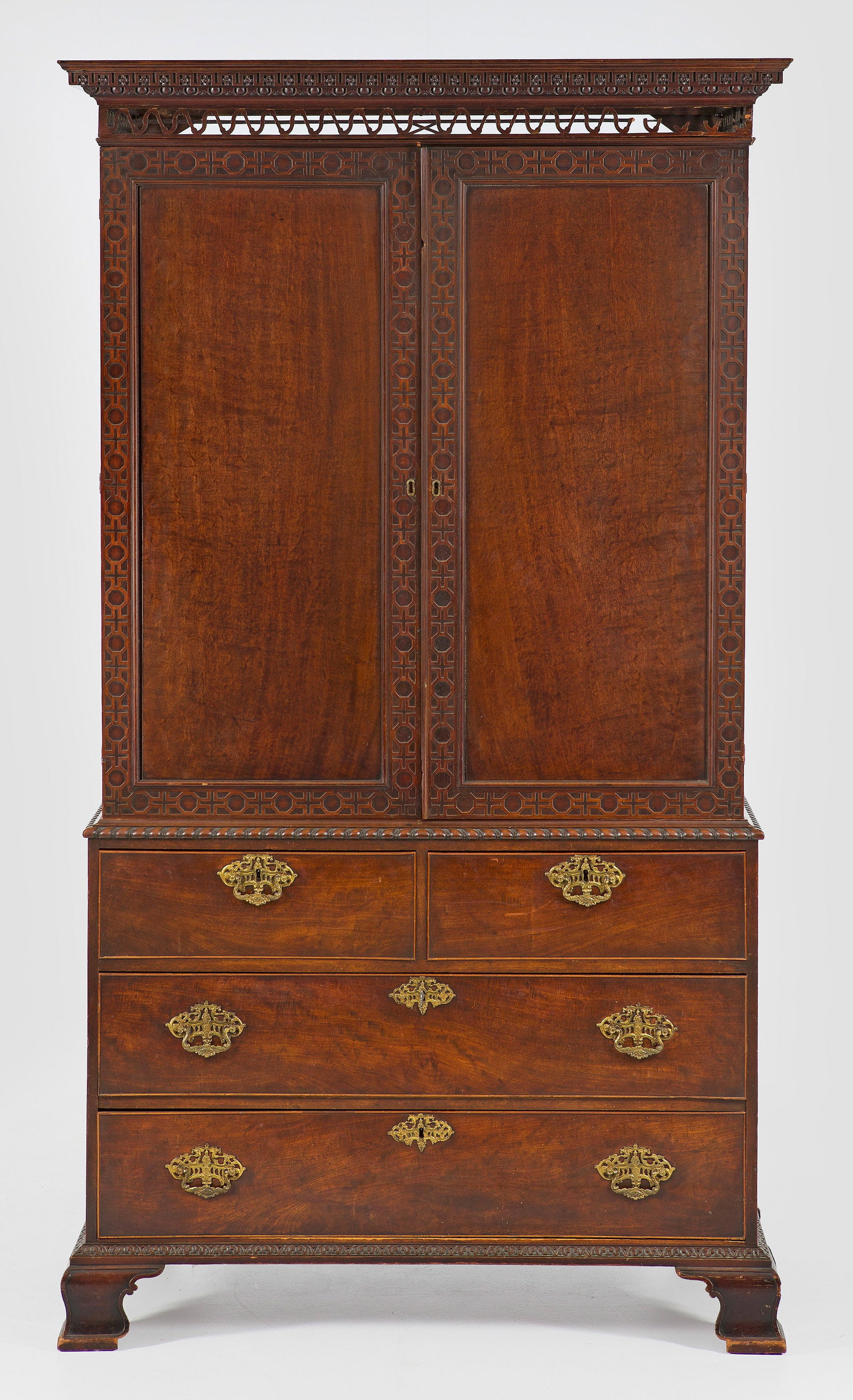 Chippendale Gentleman-Dresser: Mahagoni, furniert. Gerader, querrechteckig angelegter Korpus auf schmaler reliefierter Zarge und breiten, geschwungenen Füßen. In der gegliederten Front vier Schubladen unterschiedlicher Größe. O