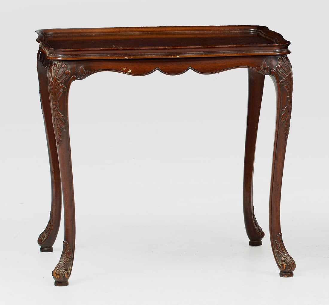 Teetisch im Chippendale-Stil: Mahagoni. Passig geschweifte Zarge auf geschwungenen, blattreliefierten Beinen. Gering überstehende, profilgerahmte Deckplatte mit flacher Galerierahmung. H. 67 cm. 69 cm x 54,5 cm. An English