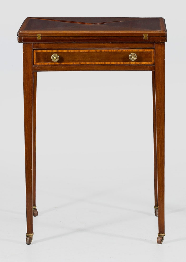 Edwardianischer Spieltisch: Mahagoni, massiv und furniert. Gerader, einschübiger Zargenkasten auf konischen Vierkantbeinen mit Rollen. Gering überstehende, aufklappbare Deckplatte. Unterhalb grüne Spielfläche. H. 75,5 cm.