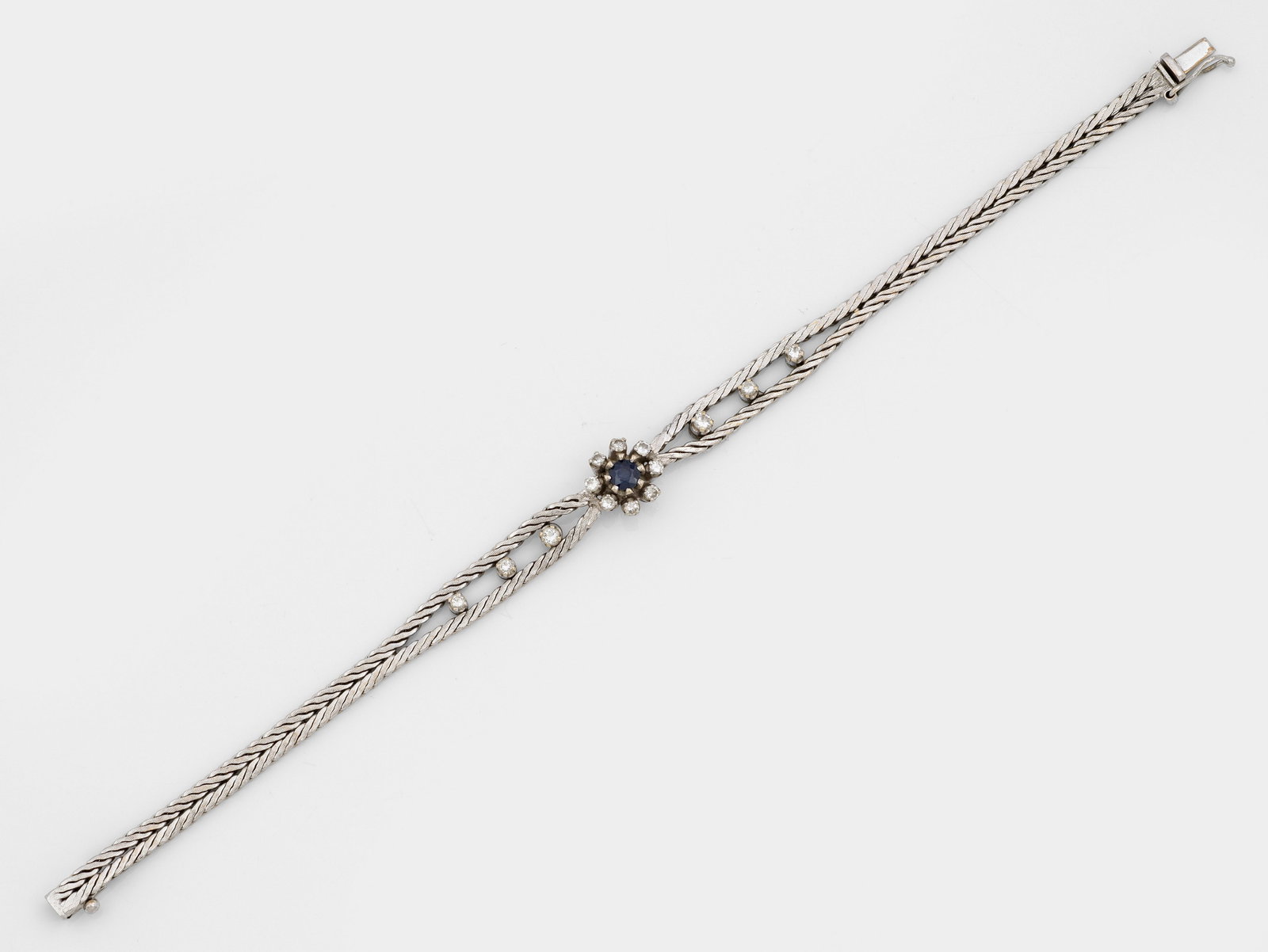 Feines Saphir-Brillant-Armband: Weißgold, gest. 750. Fischgratband, schauseitig besetzt mit kleinen Brillanten von zus. ca. 0,40 ct.; Gew. ca. 15,86 g. Bracelet set with sapphires and diamonds approx. 0,40 ct., in 18 k white gold.