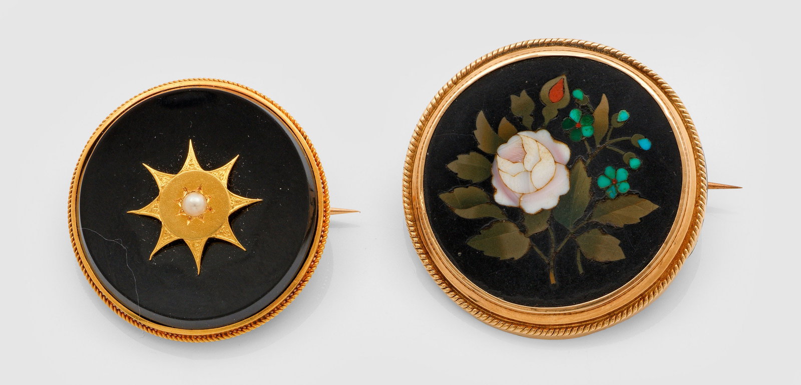 Zwei Spätbiedermeier-Broschen: Gelbgold,14 ct.; Schauseitig besetzt mit schwarzem Onyx und kleiner Saatperle sowie Blütenzweig in feiner polychromer Pietra Dura Technik. Ges.-Gew. ca. 22,20 g. Two late Biedermeier brooches, in 14