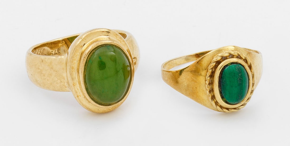 Zwei Bandringe mit Jade-Malachit: Gelbgold, gest. 375/585. Zentral besetzt mit Jade-Malachit-Cabochons. Ges.- Gew. ca. 7,91 g. Two rings set with jade and malachite, in 8/14 k gold.