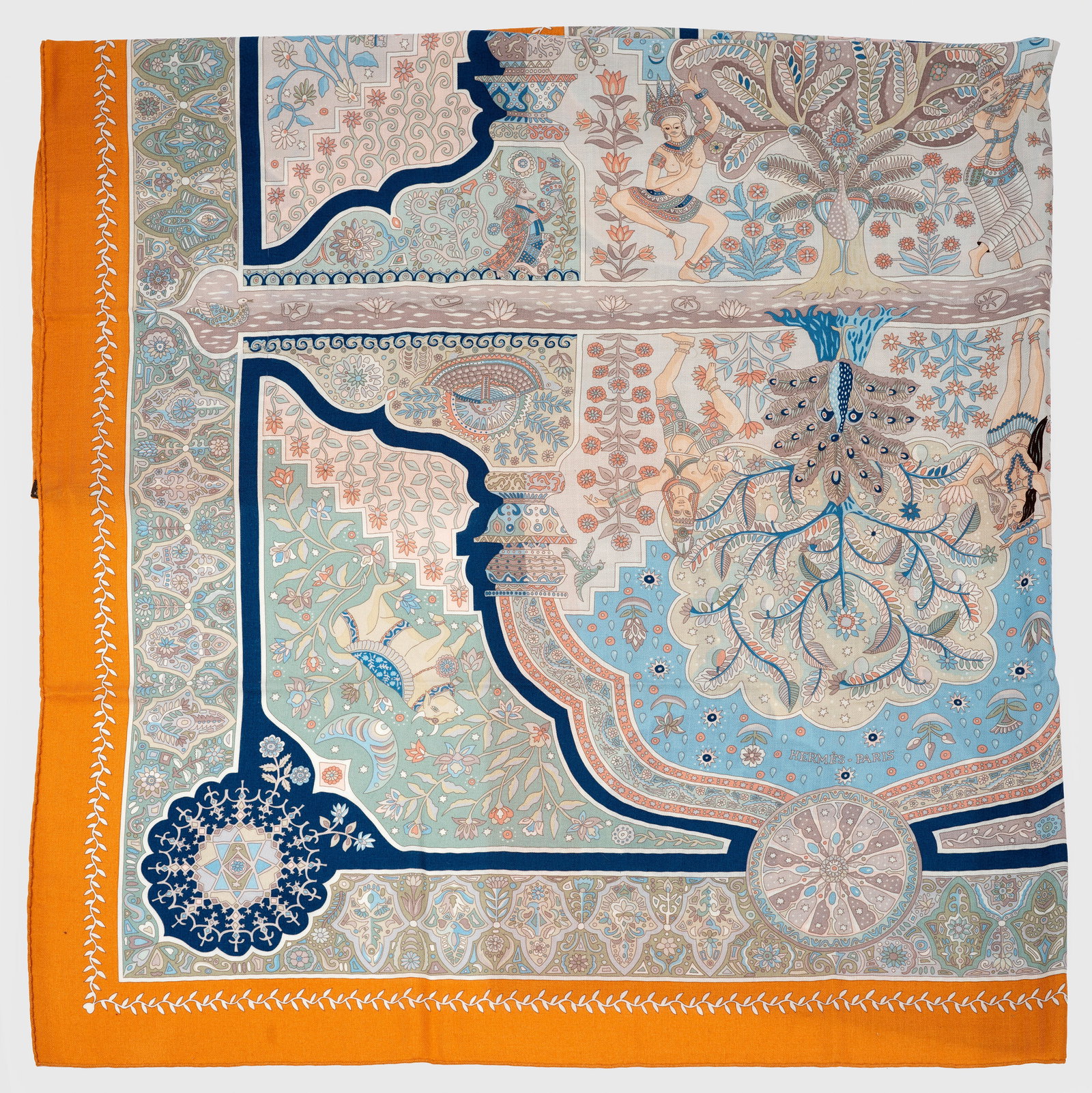 Cashmere Seiden-Schal "Aux Portes du Palais" von HERMÈS: mit Box. Sog. "le Carré". Großes quadratisches Tuch. Auf orangegerahmten, hellem Fond große Kartusche mit Baummotiven und indischen Tempeltänzern sowie unterschiedlichen Tierdarstellungen in den E