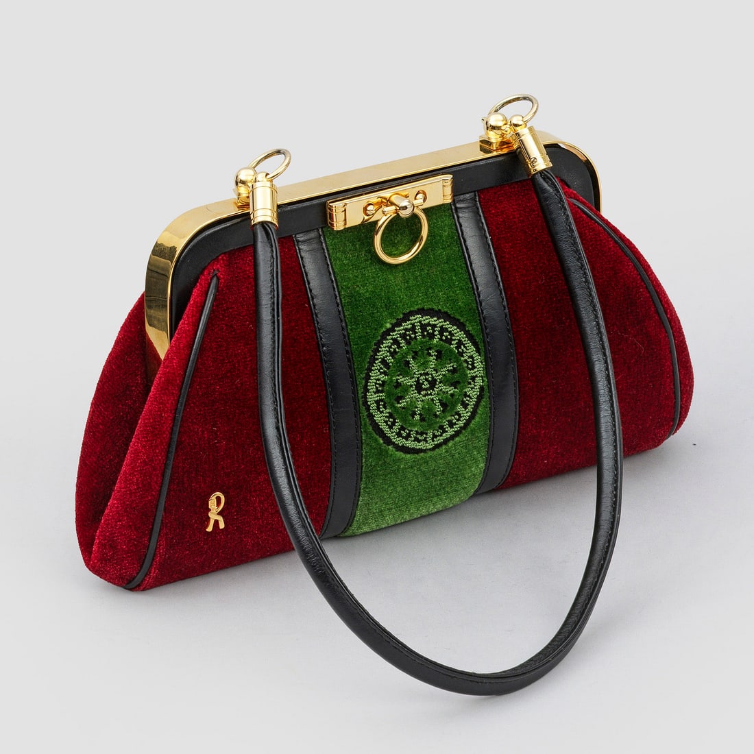 Kleine Handtasche von Roberta di Camerino: Bordeauxroter und grüner Samt sowie schwarzes Leder und vergoldete Hardware. Bombierter Korpus mit Zentralverschluss sowie schmaler Handhabe. Herstellerzeichen. Staubbeutel. H. 13 cm. 25 cm x 4 cm. A