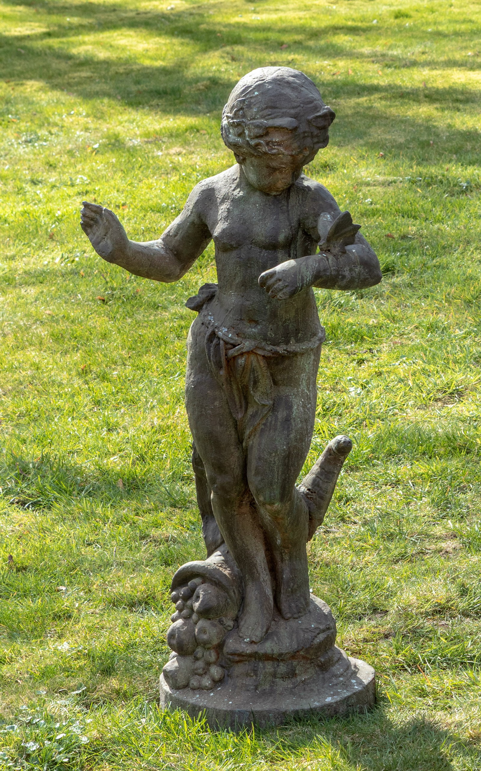 Zeitgenössischer Bildhauer: (Tätig im 20. Jh.) Jüngling mit Schmetterling Gusseisen, dunkel patiniert. Auf Rundsockel mit umgestürztem Fruchtkorb stehender Knabe mit Haarschmuck, einen Lendenschurz tragend, den Schmetterling