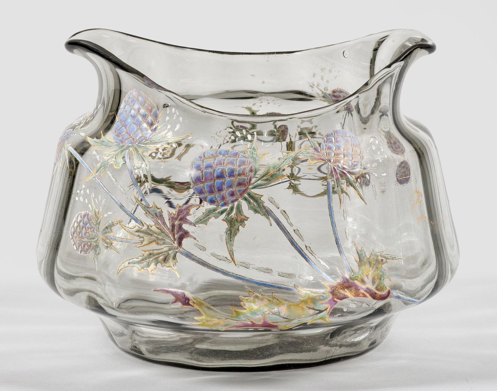 Seltene frühe Ziervase mit Distel-Dekor: "Chardons de Lorraine" von Emile Gallé Gebauchte, leicht ins Oval gedrückte Form mit weiter Öffnung, zu zwei Seiten zungenartig ausgezogen. Hellgraublaues, transparentes, längsoptisch geblasenes G