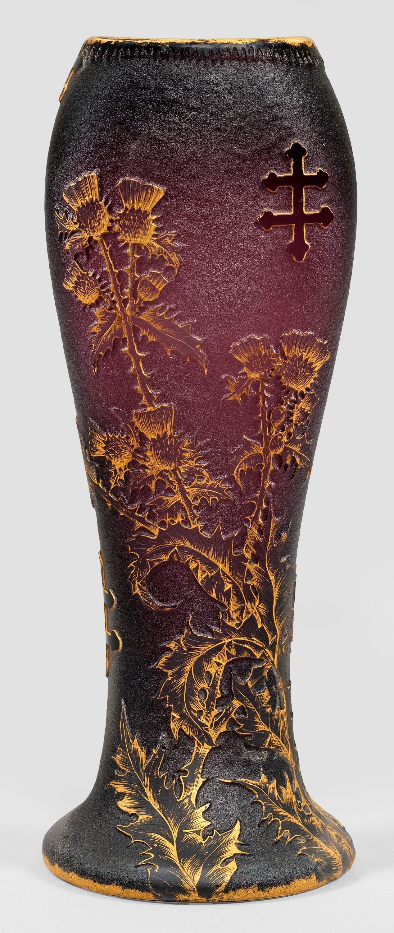 Hohe Vase mit Distel-Dekor "Chardons de Lorraine": von Daum Frères Auf rundem, ausschwingendem Fuß beidseitig abgeplattete Keulenform. Überfangglas, farblos und violett. Geätzter, gravierter und vergoldeter Dekor aus blühenden Lothringer Disteln 