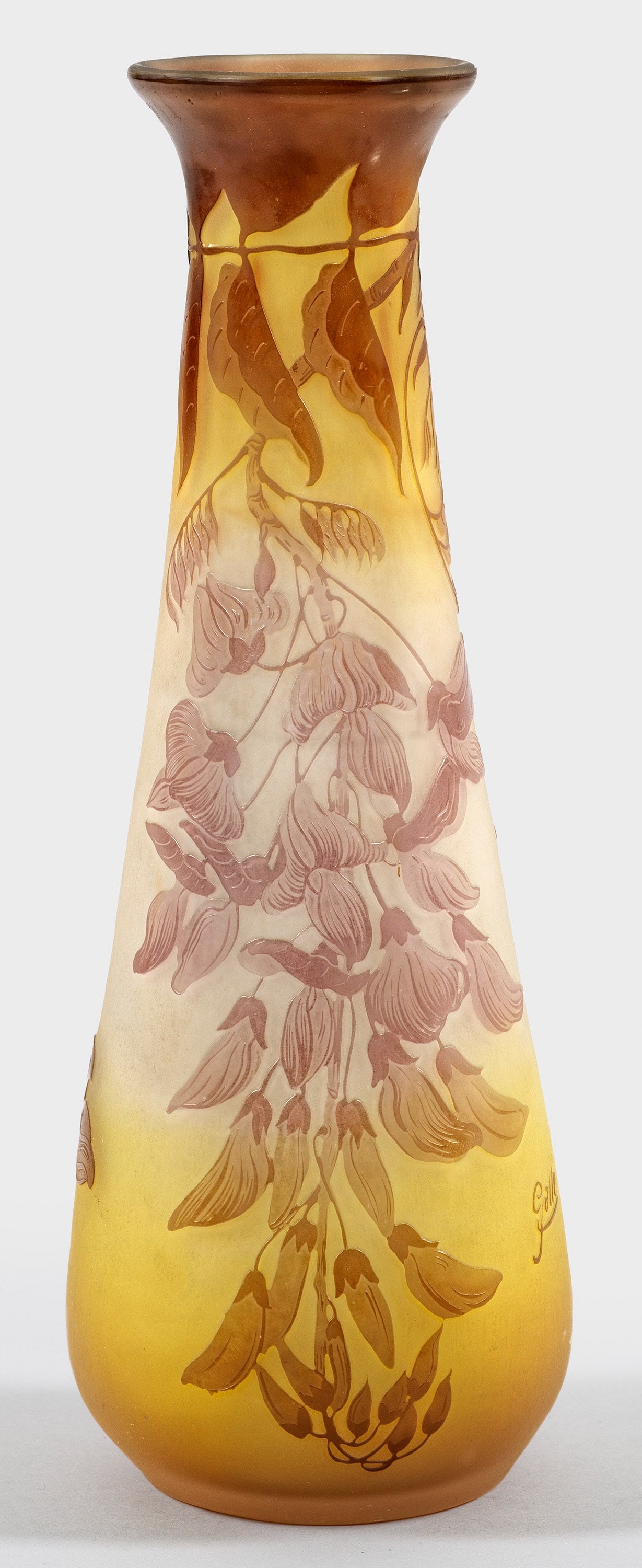 Jugendstil-Ziervase mit Blauregen-Dekor von Emile Gallé: Keulenform mit ausschwingendem Rand. Überfangglas, farblos, gelb und violett. In mehreren Arbeitsgängen ausgeführter, geätzter und polierter, umlaufender Dekor aus blühenden Ranken von Blauregen 