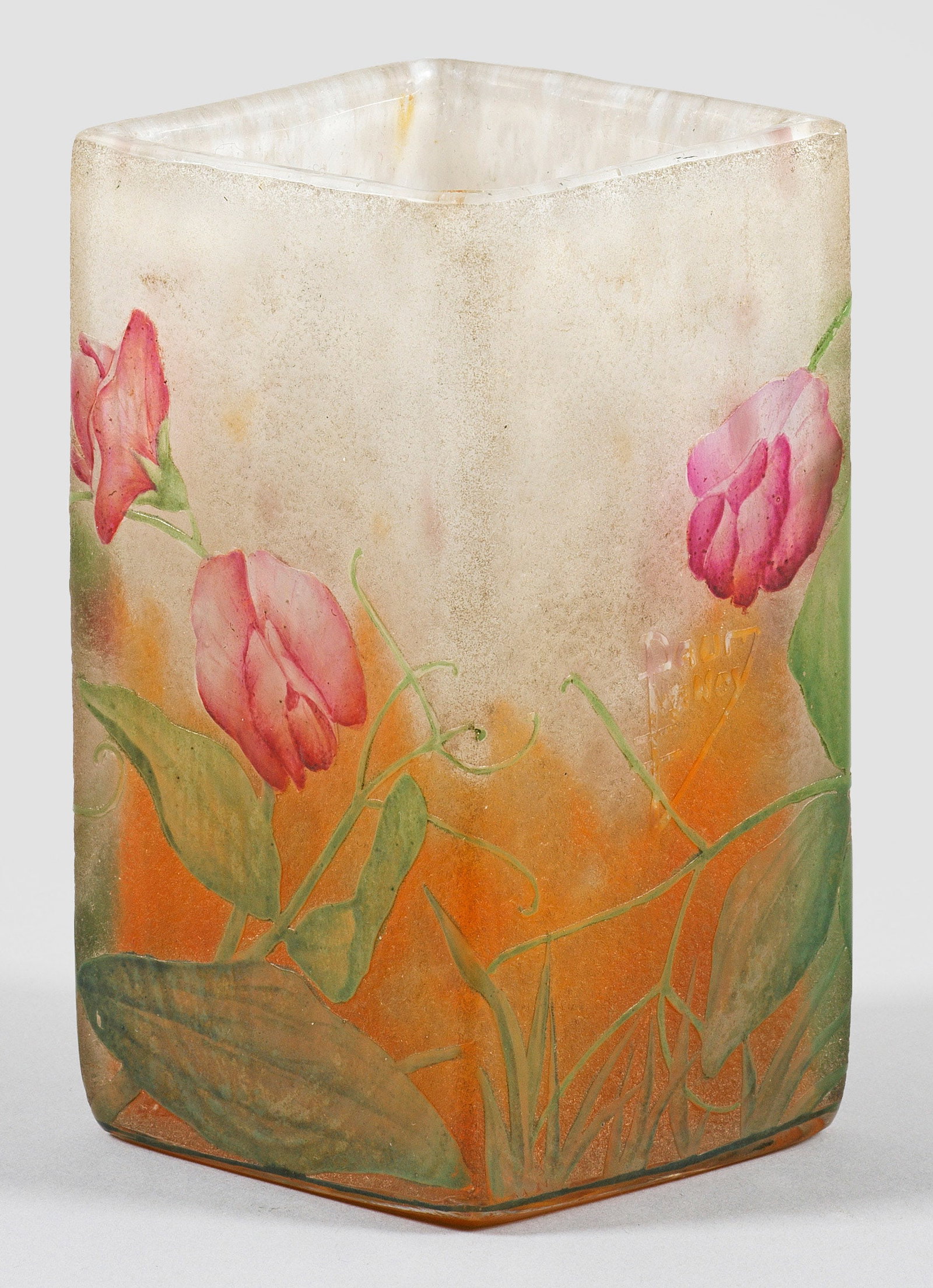 Ziervase mit Duftwicken-Dekor "Pois de Senteur" von Daum: Frères Becherform mit rautenförmigem Querschnitt und gerade hochgezogener Wandung. Überfangglas, farblos, Pulvereinschmelzungen in Weiß und Orangerot. Umlaufender Dekor aus blühenden Ranken der D