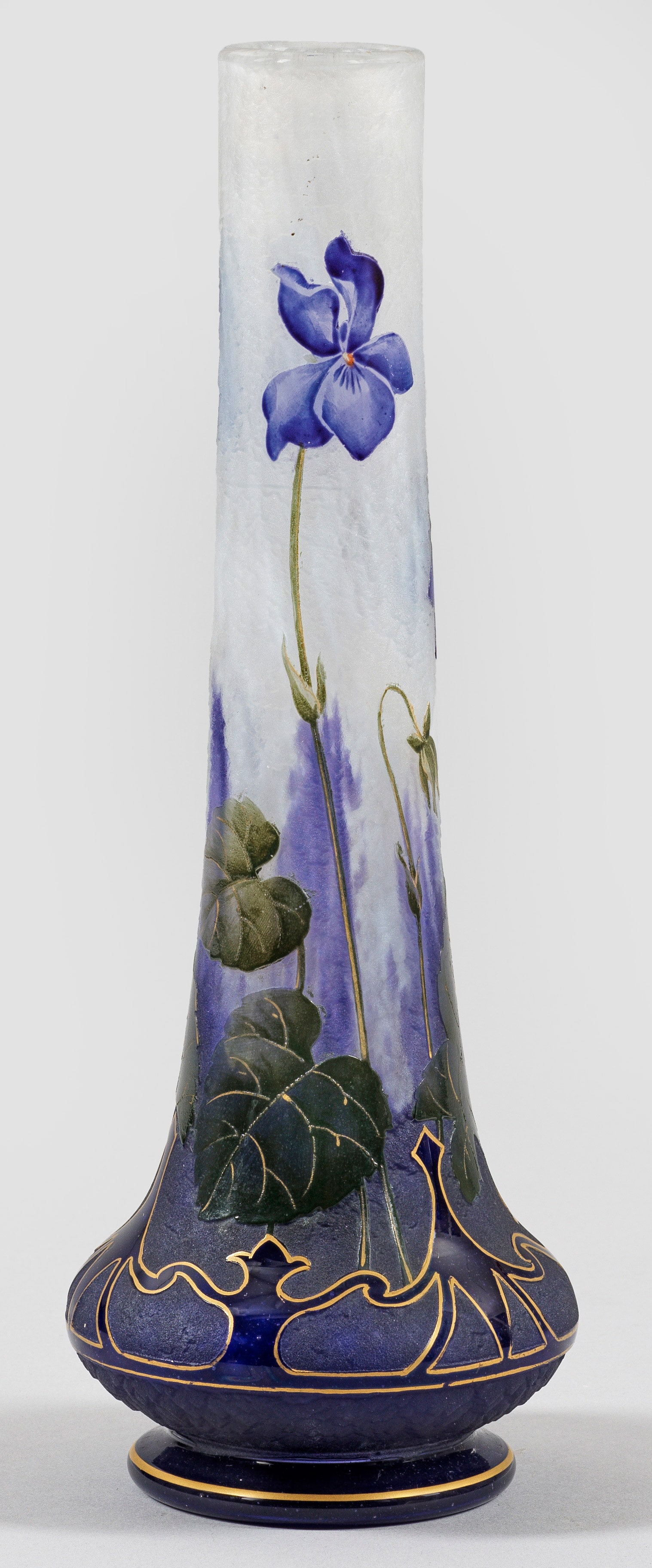 Jugendstil-Ziervase mit Veilchen-Dekor von Daum Frères: Unterhalb gebauchte Keulenform. Überfangglas, farblos, mit flockigen, weißen und dichten violetten Pulvereinschlüssen. Umlaufender Dekor aus blühenden Veilchen, am Ansatz ornamentales Band, geätz