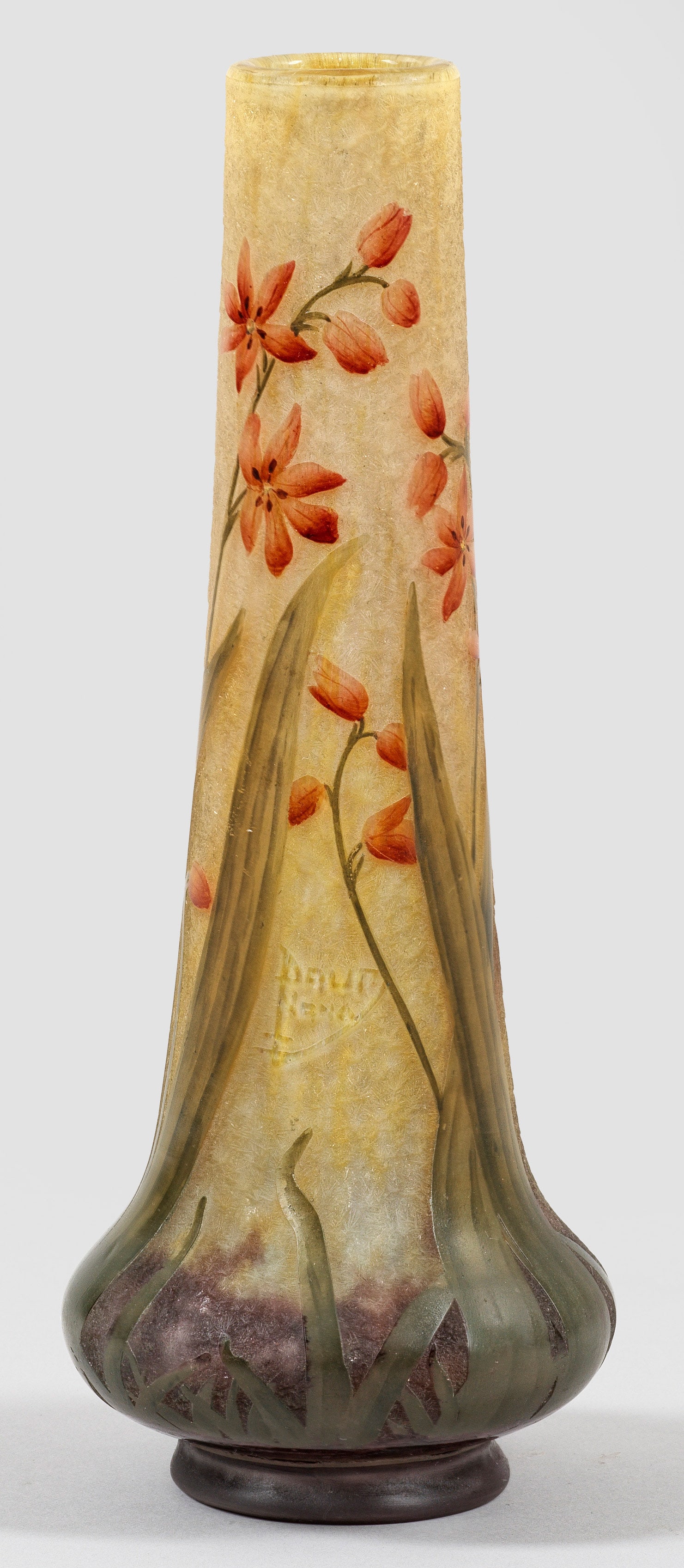 Jugendstil-Ziervase mit Kaffernlilien-Dekor von Daum Frères: Unterhalb gebauchte Keulenform. Überfangglas, farblos, flockige, gelbe und dunkelviolette Pulvereinschlüsse. Umlaufender Dekor aus blühenden Stängeln der Kaffernlilie (Hesperantha coccinea), geät