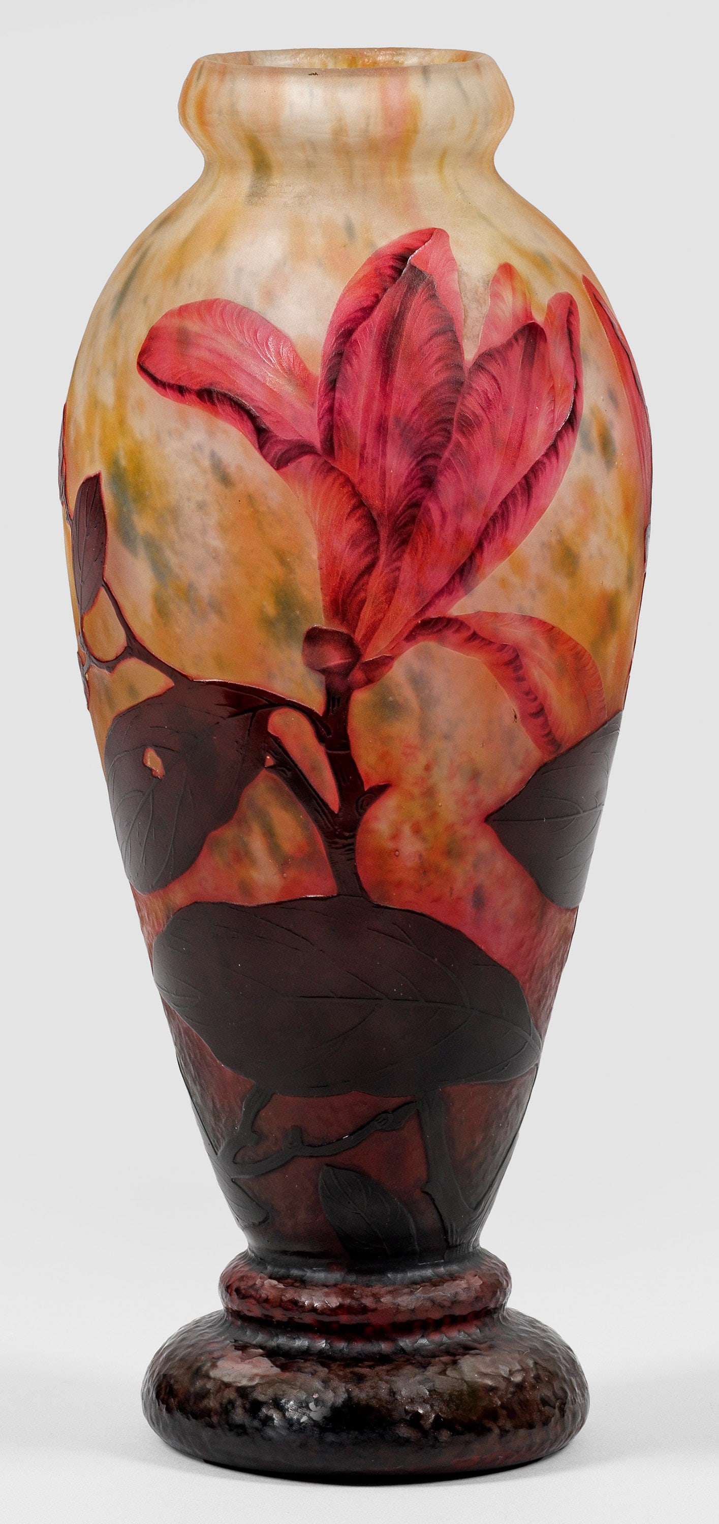 Vase mit Dekor "Magnolias": Über profiliertem Fußwulst ovoider Korpus mit eingeschnürtem Mündungsring. Farbloses Glas mit grünen und gelben Pulvereinschmelzungen, violett und rosa überfangen, geätzter Dekor, am Fuß Marte