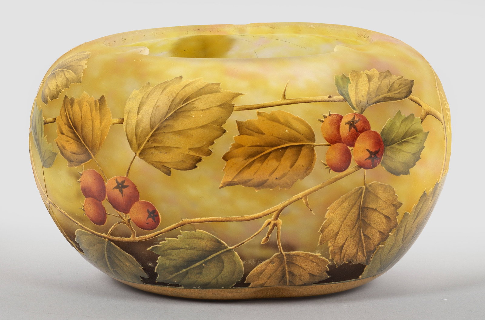 Jugendstil-Ziervase mit Weißdorn-Dekor von Daum Frères: Gedrückte Kugelform mit dreipassig eingezogener Mündung. Überfangglas, farblos mit geflockten, weißlichen, gelben und dunkelvioletten Pulvereinschmelzungen, die Deckschicht mit ockerfarbenen Ein- 