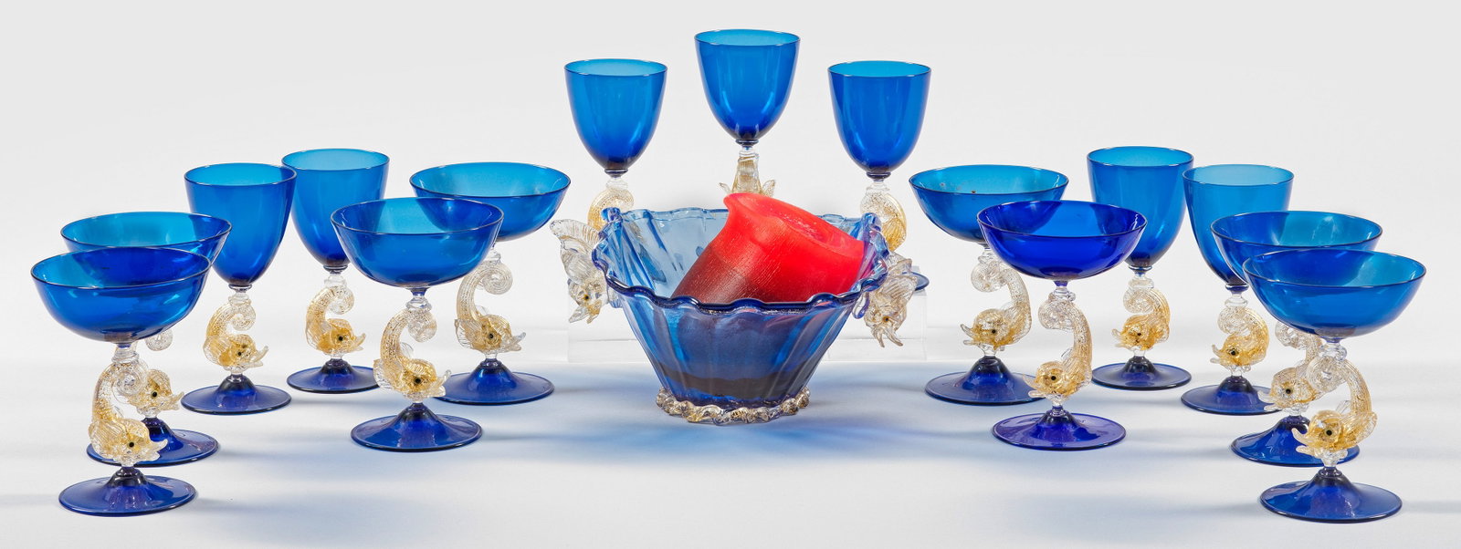 Murano-Glasservice mit Delfinen: 16-tlg.; Dunkelblaues und farbloses Glas, partiell mit Einschmelzungen aus fein zersprengter Goldfolie. Bestehend aus einer längsoptisch geblasenen, muschelförmigen, ovalen Zierschale mit zwei plast