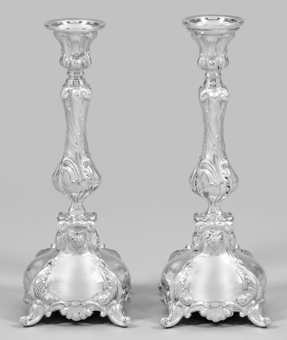 Paar Tafelleuchter im Barockstil: Silber. Gewölbter Stand, beschwert. Über konsolartigem Ansatz mehrfach gegliederter Schaft mit vasenförmiger Tülle und reichem Reliefdekor. Gest. 925. Ges.-Gew. 1050 g. H. 24,5 cm. A pair of Germa