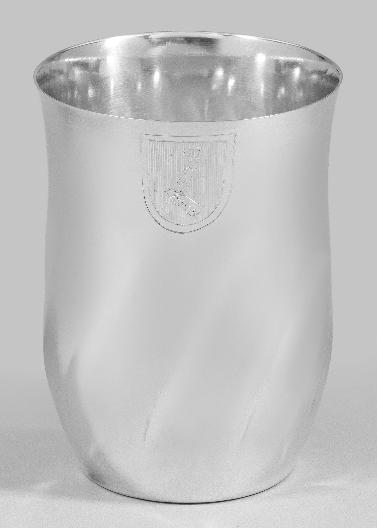 Becher mit persönlichem Wappen: Silber. Auf runder Standfläche leicht gebauchter Korpus, durch schräge Züge umlaufend gegliedert. Glatter Randbereich leicht ausschwingend und schauseitig graviert mit dem persönlichen Wappen von 