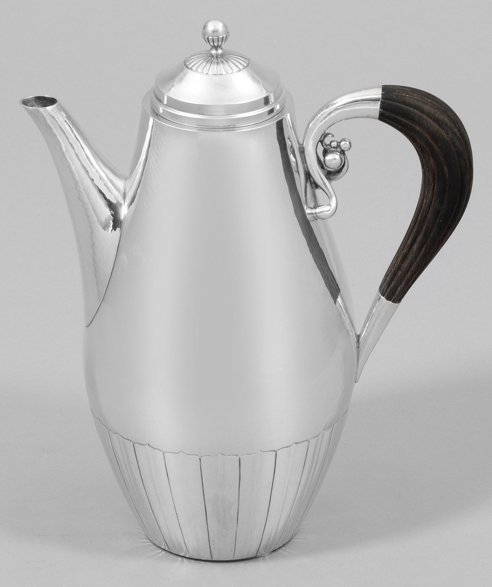 Georg Jensen-Kaffekanne "Cosmos": Sterlingsilber. Birnförmiger Korpus mit feinem Hammerschlagdekor. Geschwungener, kannelierter Henkel aus ebonisiertem Holz. Am oberen Henkelansatz eine kleine, mit Kugeln besetzte Volute. Gest. 925 s