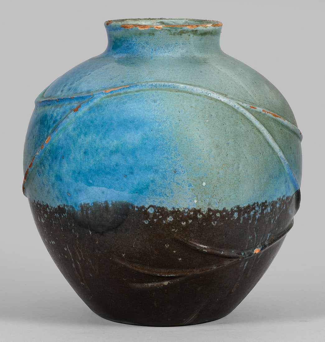 Vase mit Reliefzweigen: Majolika, ziegelfarbener Scherben mit schwarzer und blauer Glasur. Über dem Rundstand kugelig gewölbter Korpus mit eingezogener Schulter und kurzer, leicht ausschwingender Mündung. Umlaufende Relie
