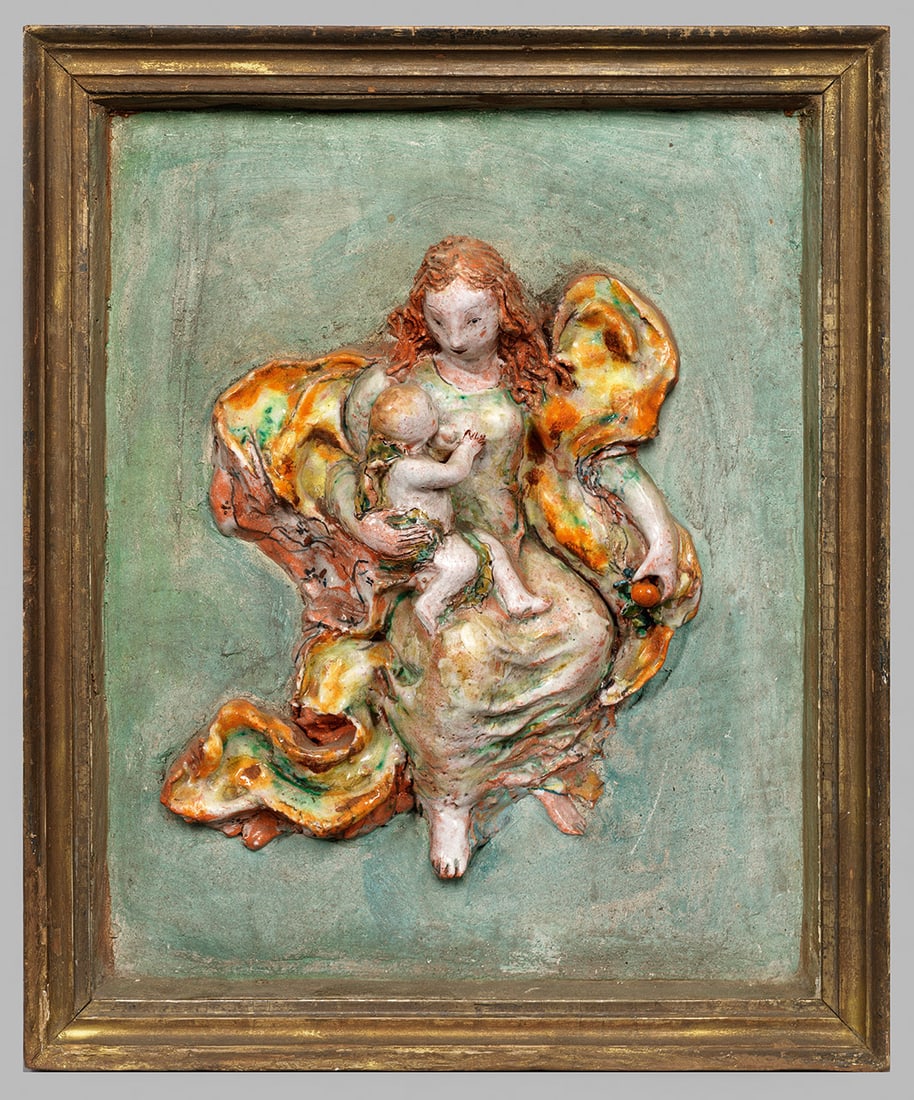 Wandbild einer Madonna mit Apfel: Irdenware, ziegelroter Scherben. Zentral auf rechteckig eingefärbter Platte die reliefplastisch gearbeitete Darstellung der Maria mit wallendem Mantel, einen Apfel und das Christuskind haltend. Polyc