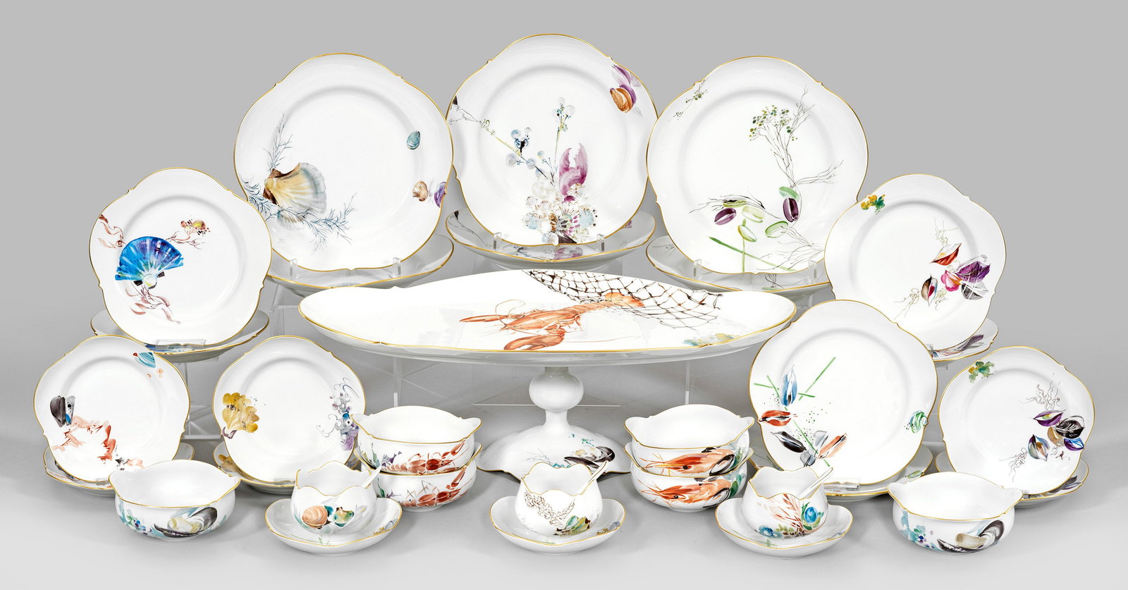 Extravagantes Hummer-Service mit Fischdekor von Meissen: 31-tlg.; 6 Speiseteller, 6 Vorspeiseteller, 6 Dessertteller, 6 Suppentassen, 3 Schälchen mit Untertassen, drei Löffel und Tafelaufsatz. Auf der Wandung und im Spiegel verschiedene Wasserpflanzen und